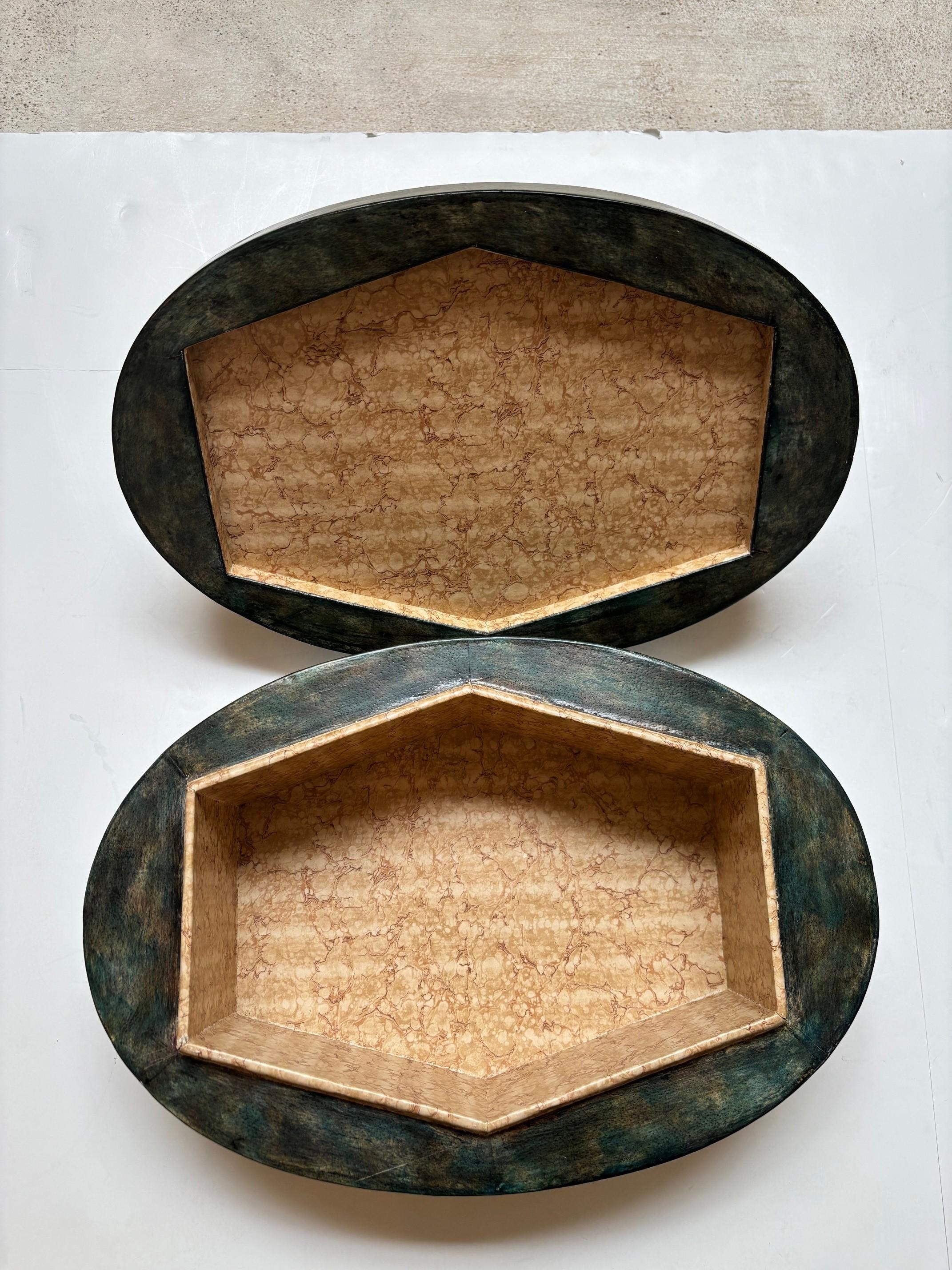 Scimmia figurata in fusione d'argento su una scatola con coperchio in legno di Maitland Smith, con la forma di una scimmia realizzata in metallo fuso e in tonalità Siver, base in legno con decorazione in finta pelle verde impreziosita da un motivo