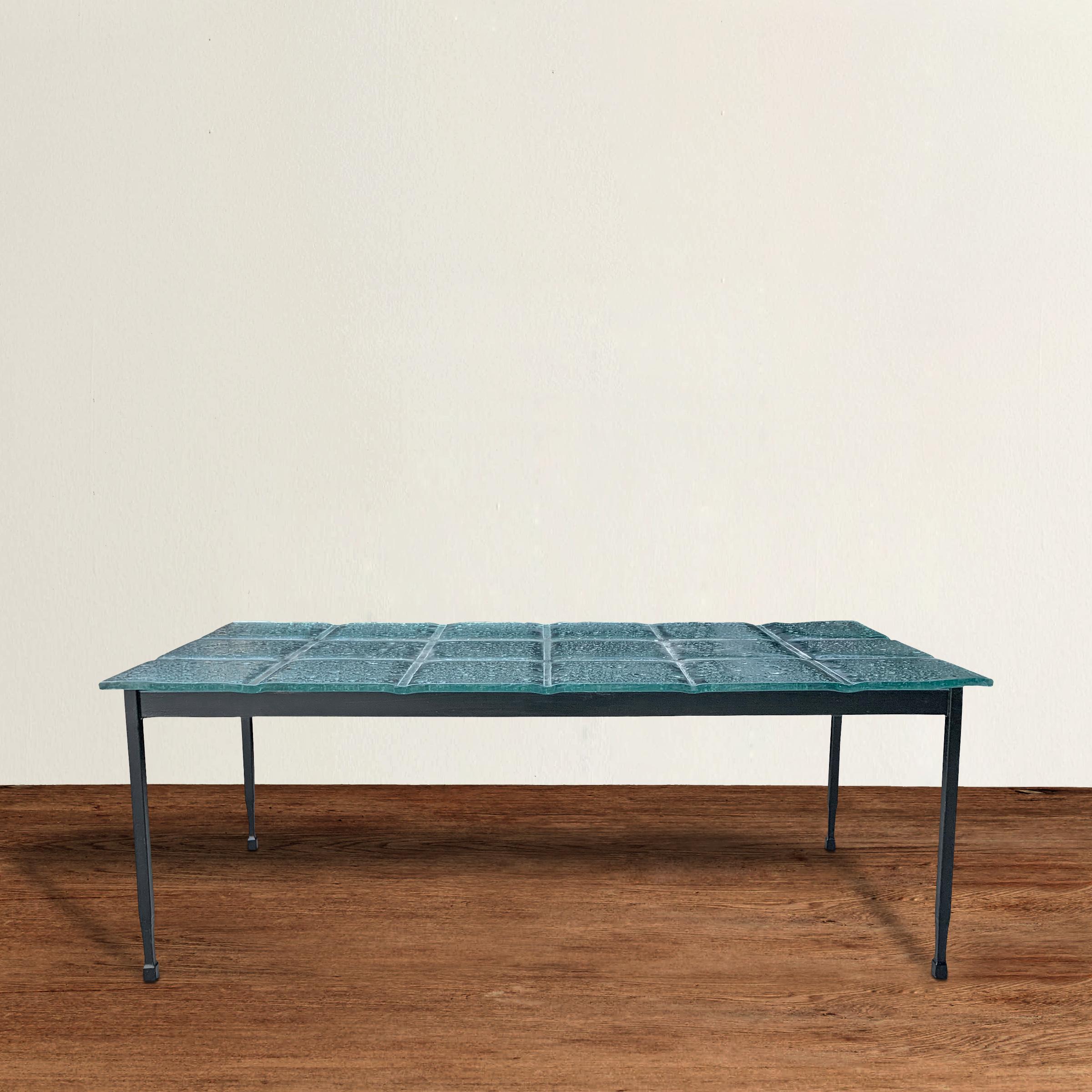An awesome vintage American low table with a thick cast glass top with a wonderfully textured surface and simple but chic steel legs that narrow slightly at the bottom and end in a square foot.