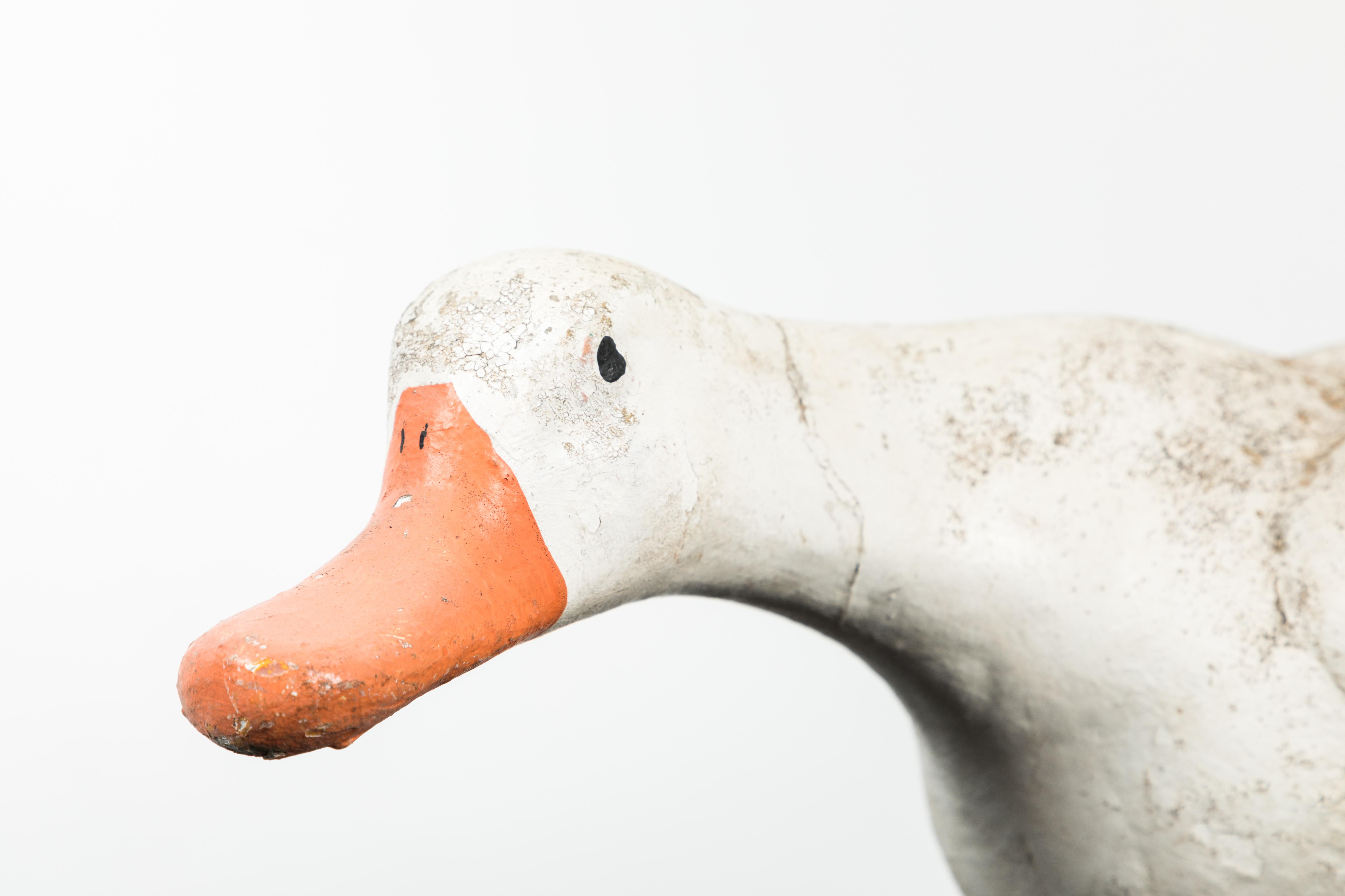 Vintage concrete and garden duck with cast iron feet. Old original paint surface.