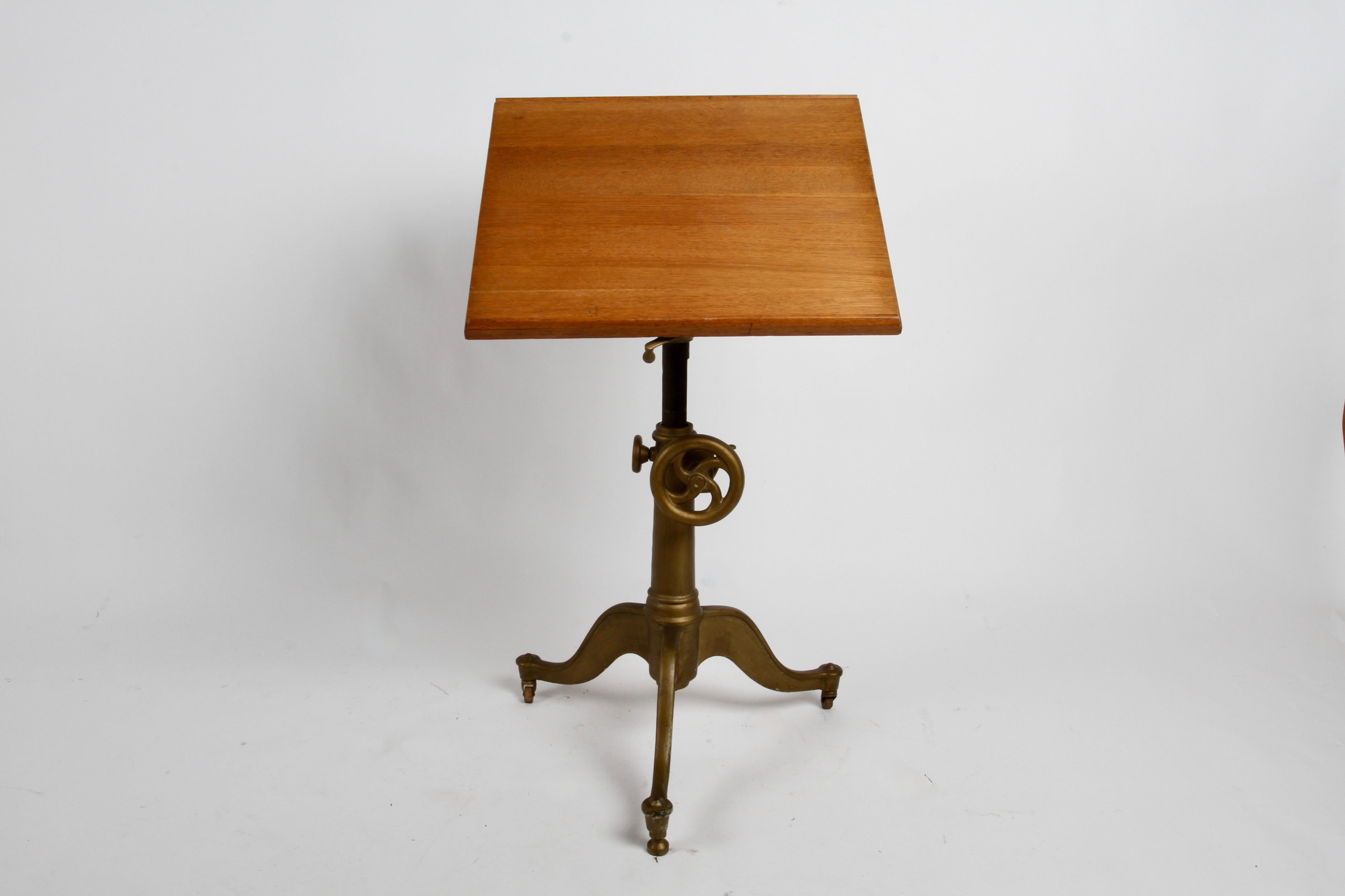 Antique American Industrial age gold painted adjustable tripod cast Iron base drafting table, art easel, lectern - podium or hostess stand with hinged oak top. In the style of Keuffel and Esser or K&E. Industrial knobs allowing for the adjustment of