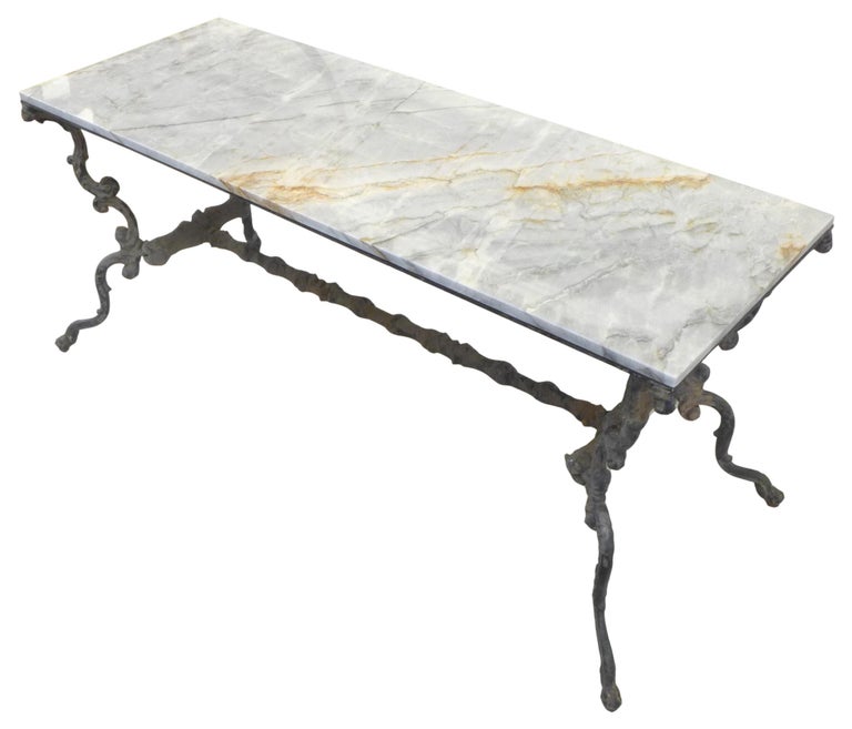 A wonderful, elegant vintage cast-iron console table with contemporary marble top. Beautifully constructed with impressive decorative appeal. Even oxidization seemingly from life outdoors consistent with age and use. Specified for both indoor and