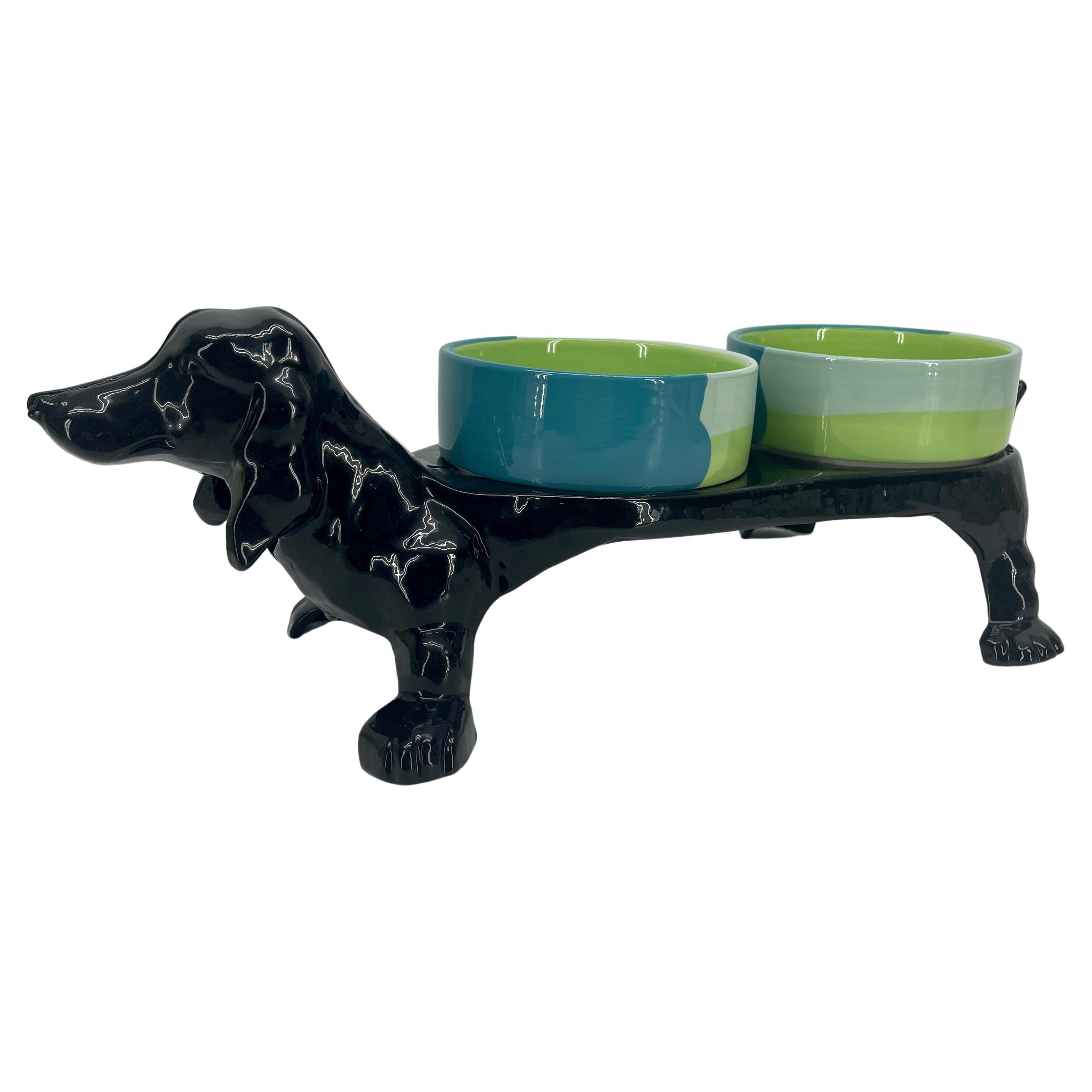 Vintage cast iron Dachshund dog bowl and feeder, circa 1920's. This nifty dog feeder holds water and food bowls fitting a variety of bowl choices. Newly powder coated in shiny black, the dachshund stands proudly ready to feed your special pup.