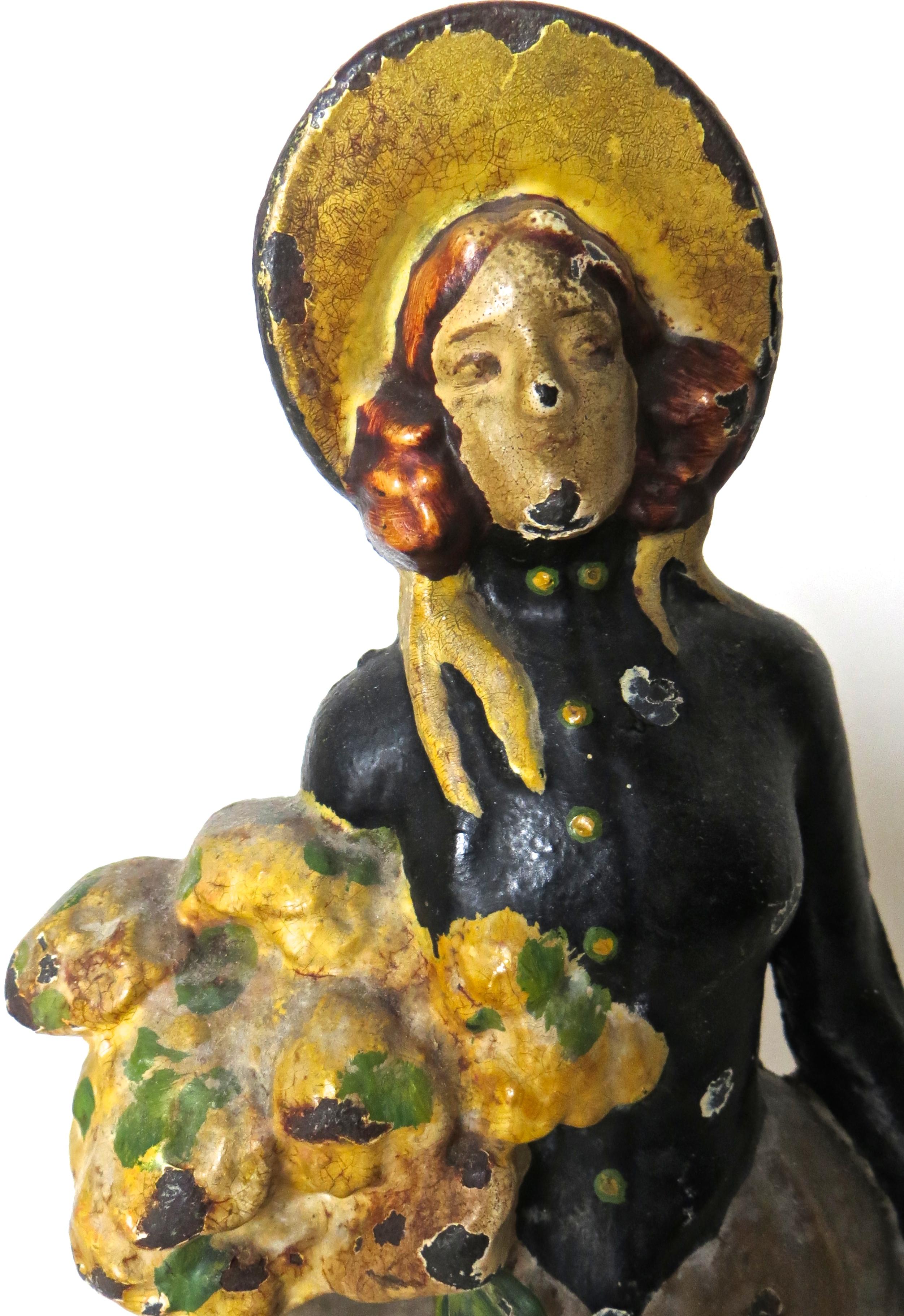 This hollow back figural doorstop features an attractive young lady carrying flowers in one arm, and a long shawl in her other arm. The doorstop is in an abundance of excellent original paint, nicely hand painted with a yellow and tan bonnet, yellow