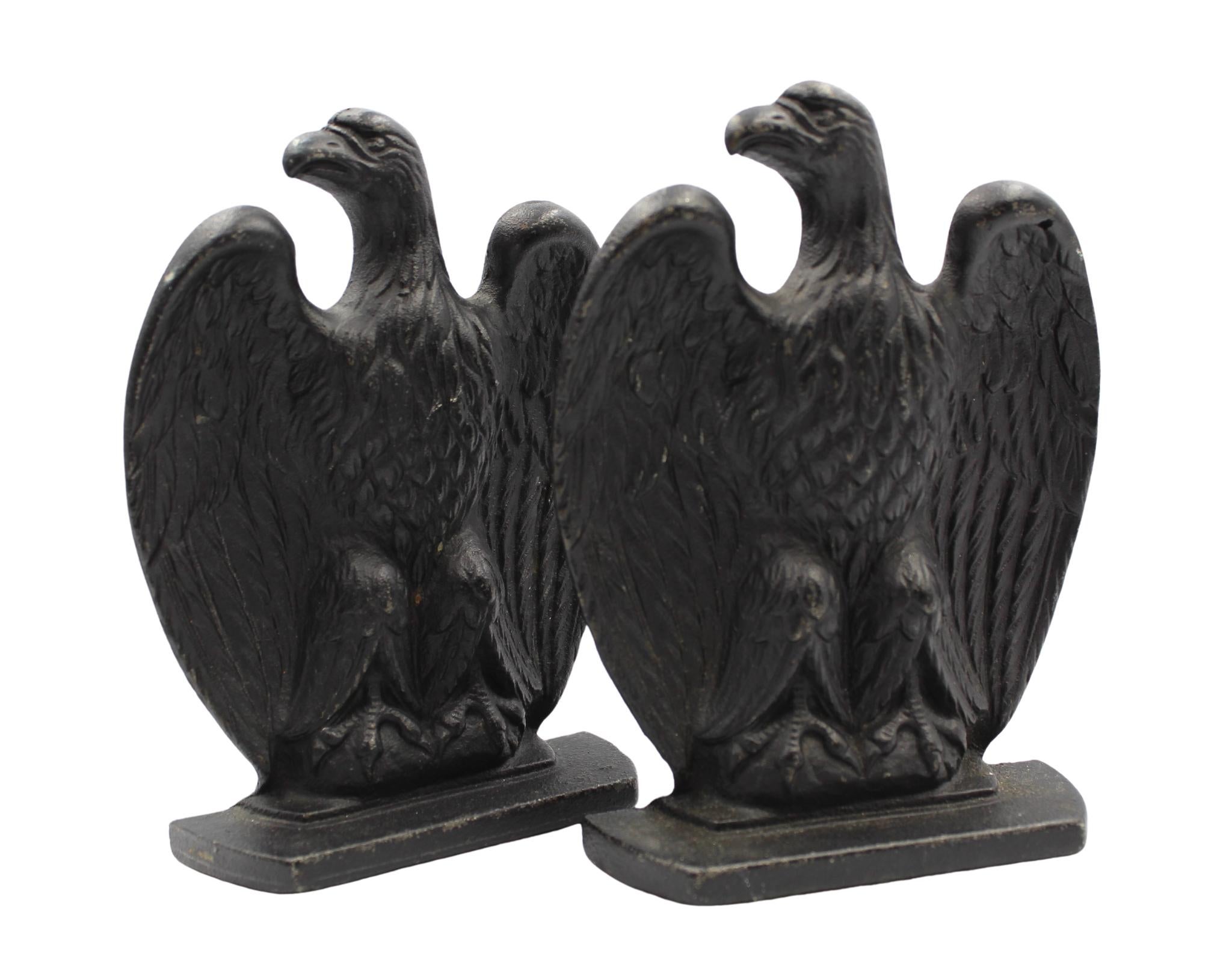 Offered is a pair of cast iron eagle bookends. These bookends each feature a perched eagle with large wings, tucked behind their bodies. The eagles' heads look to the right. The details on the wings and talons are distinctive. They are sturdy and