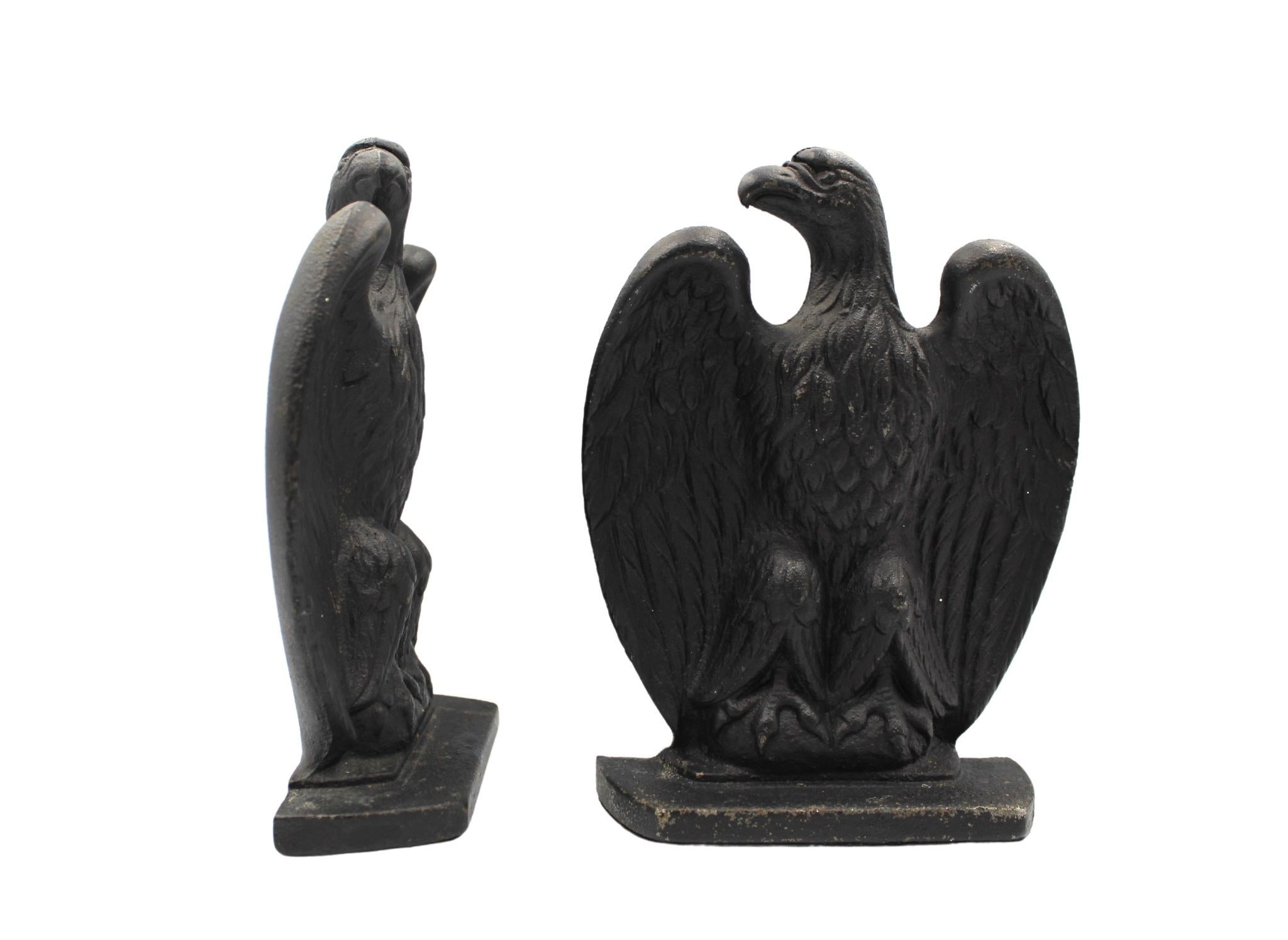 Offered is a pair of cast iron eagle bookends. These bookends each feature a perched eagle with large wings, tucked behind their bodies. The eagles' heads look to the right. The details on the wings and talons are distinctive. They are sturdy and