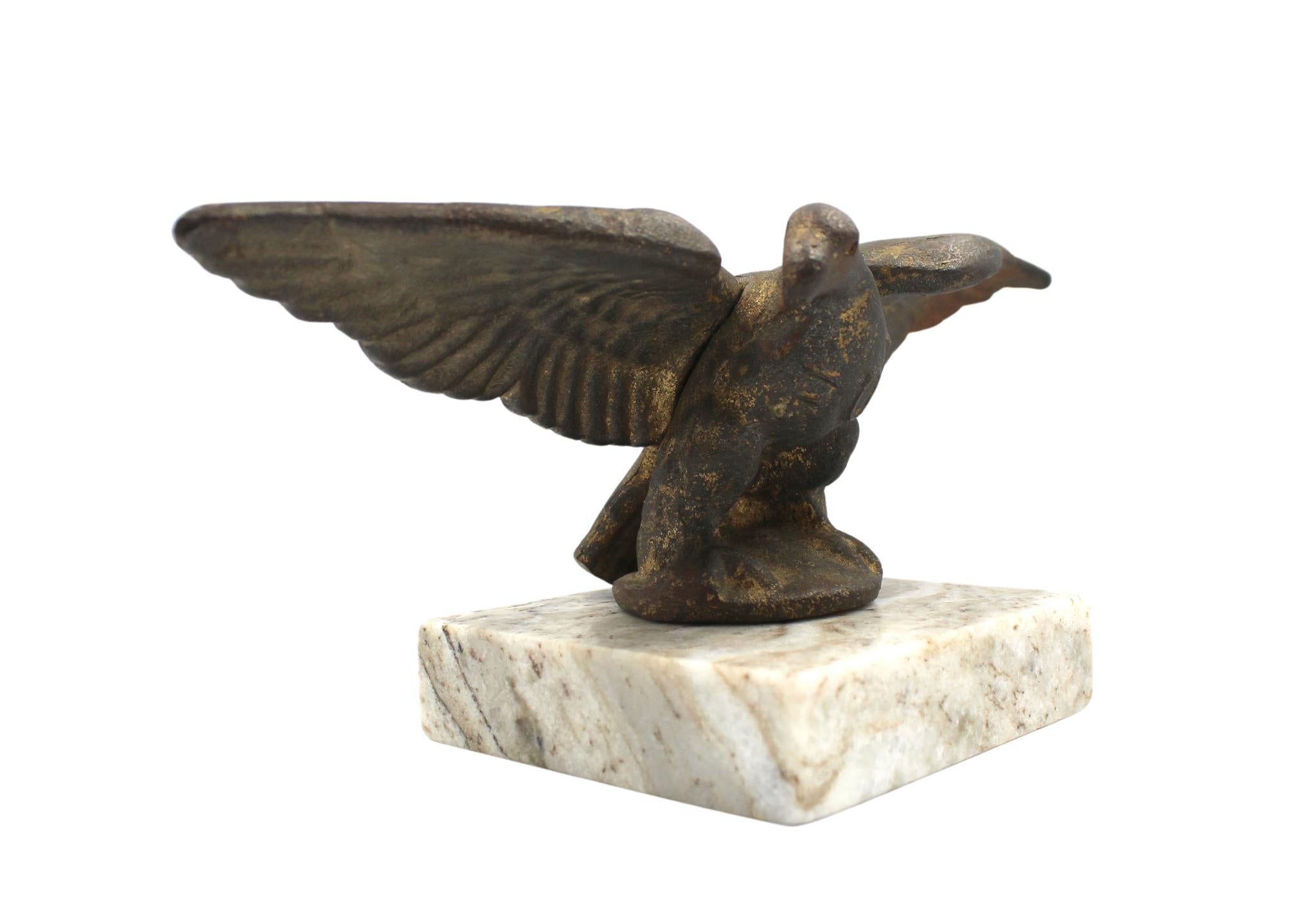 Si tratta di un fermaporta con aquila figurata in ghisa, risalente all'inizio del XX secolo. L'aquila è raffigurata ad ali spiegate, appollaiata e montata su una base di marmo quadrata. L'aquila conserva tracce della sua superficie dorata originale