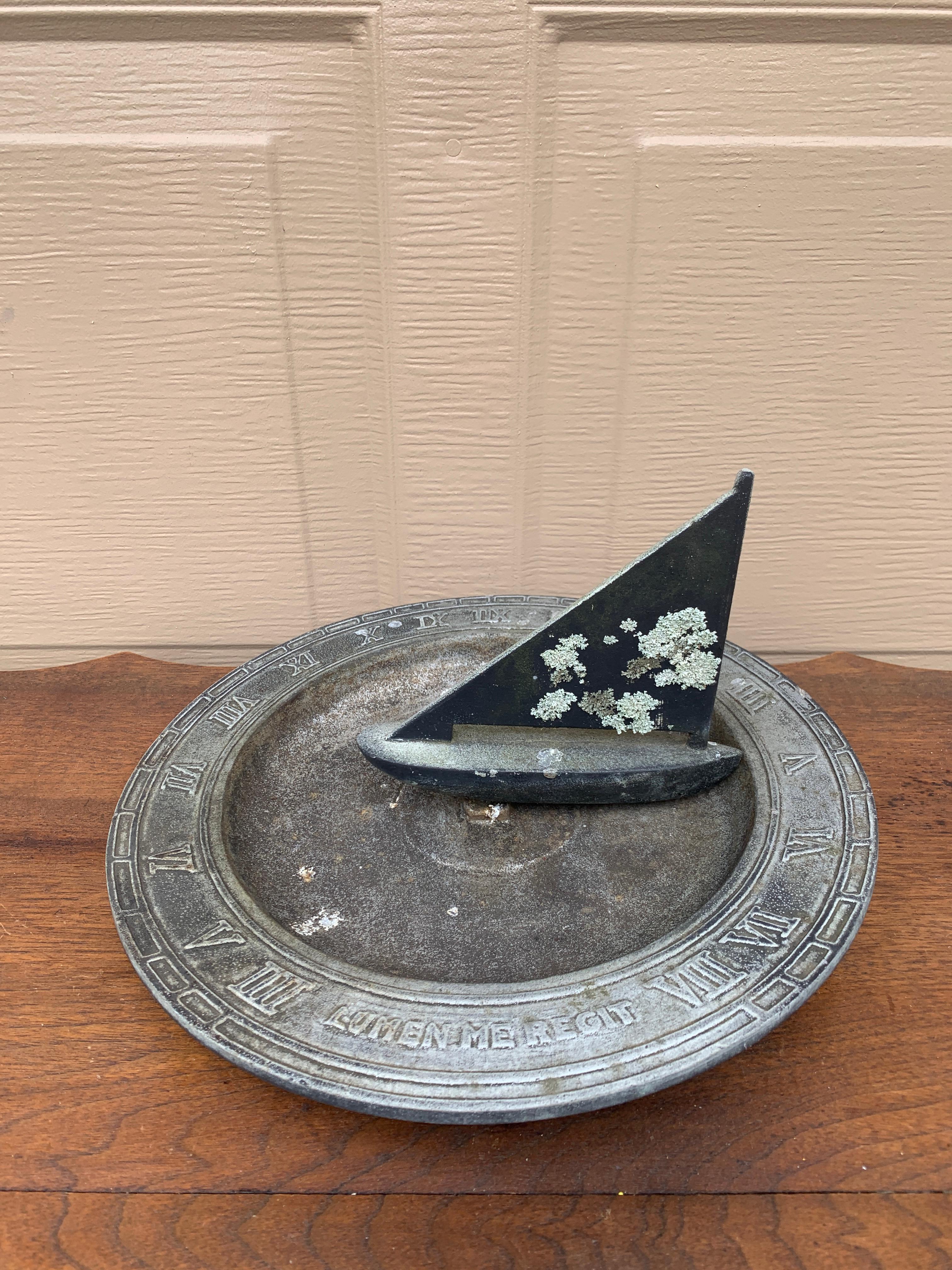 A beautiful vintage cast iron nautical garden sundial with a boat, reading 