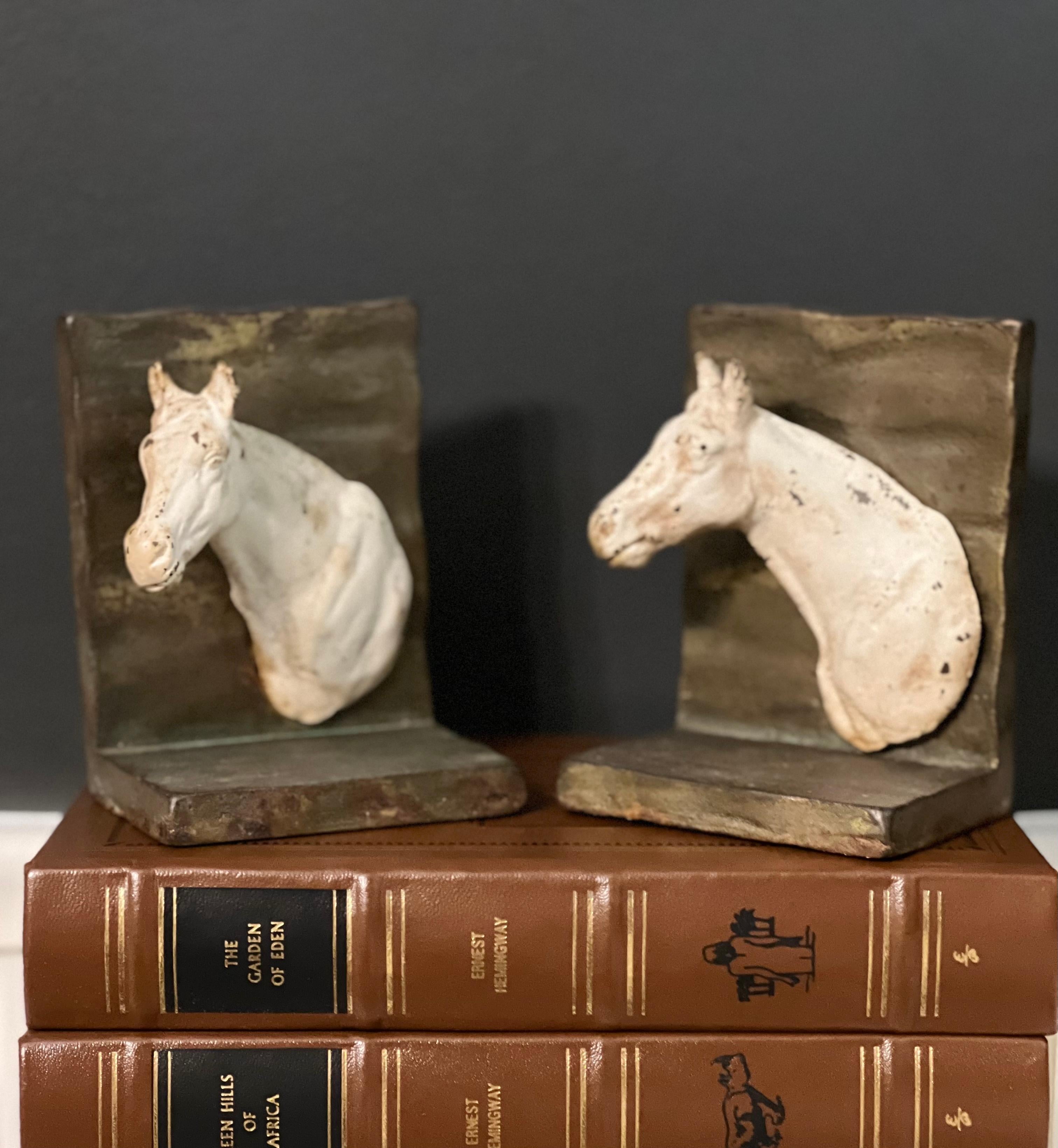 Charming vintage cast iron horse bookends, 1930's. Painted horse heads extend outward in opposite direction. Great for a touch of rustic equestrian flair to your desk, bookcase or almost anywhere.