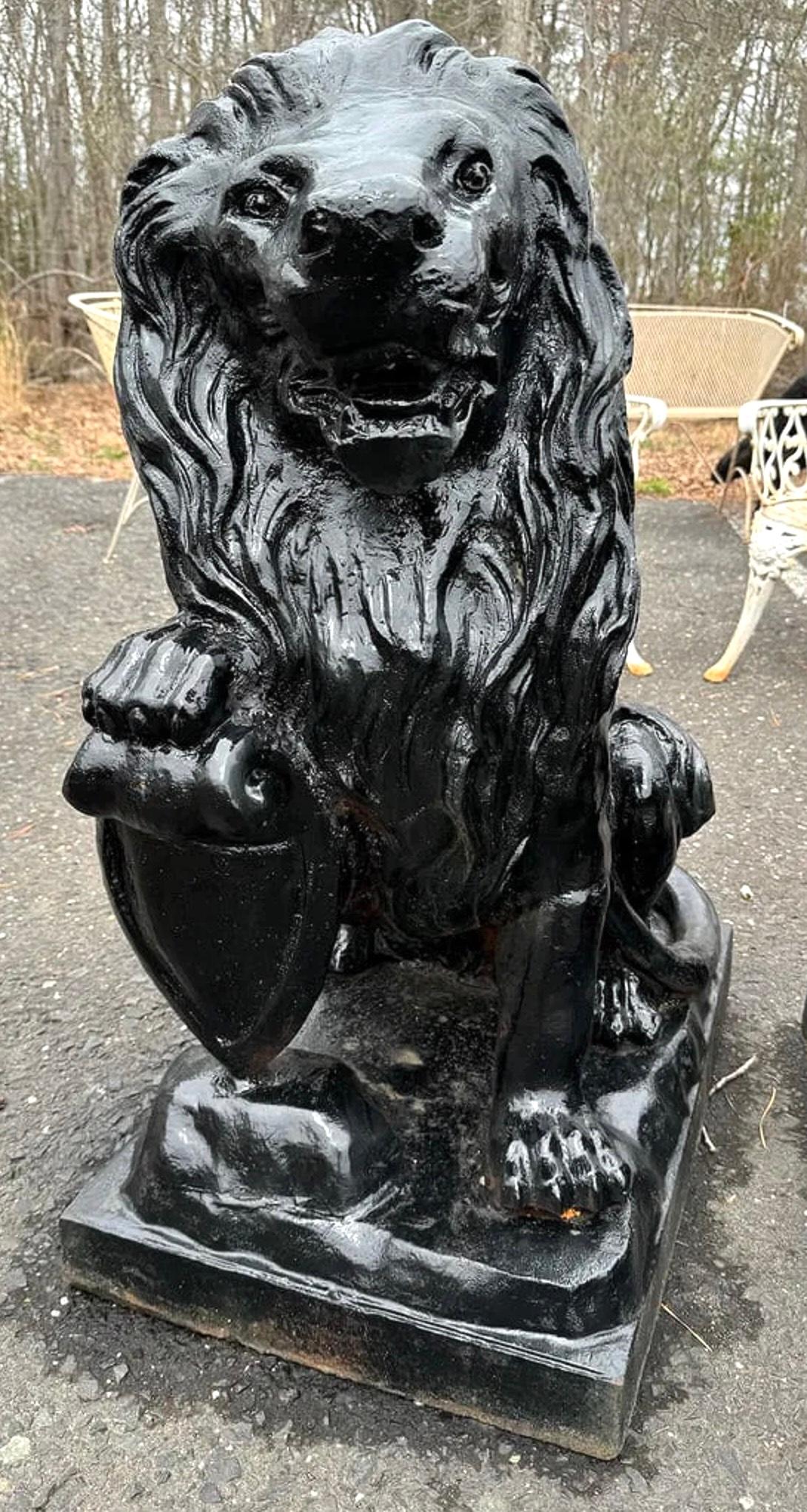 Pair of vintage cast iron lion statues with bold detailing and a classic stance. Finished with a natural patina, these heavy, durable pieces are ideal for flanking entryways, driveways, or garden paths, adding a strong and timeless presence to any