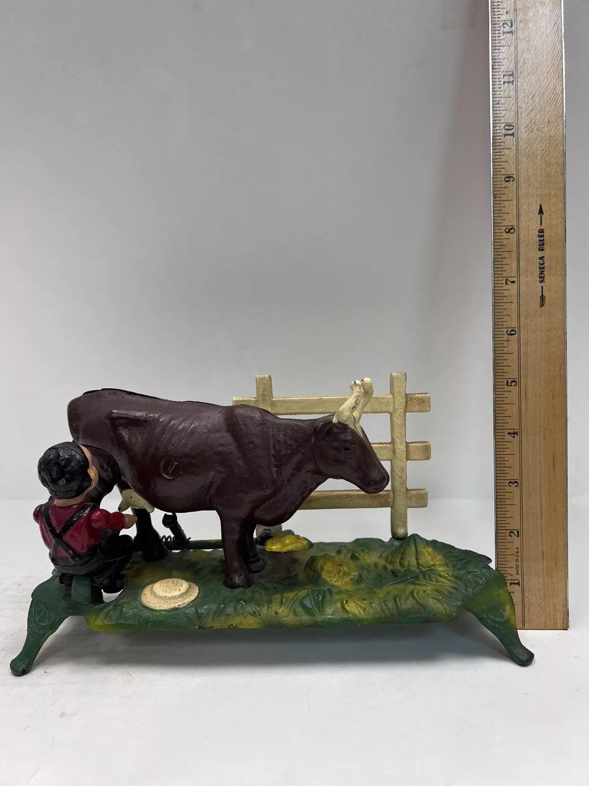 Vintage Cast Iron Mechanical Bank Book of Knowledge Kicking Milking Cow. Circa Late 20th Century. Measurements: 5