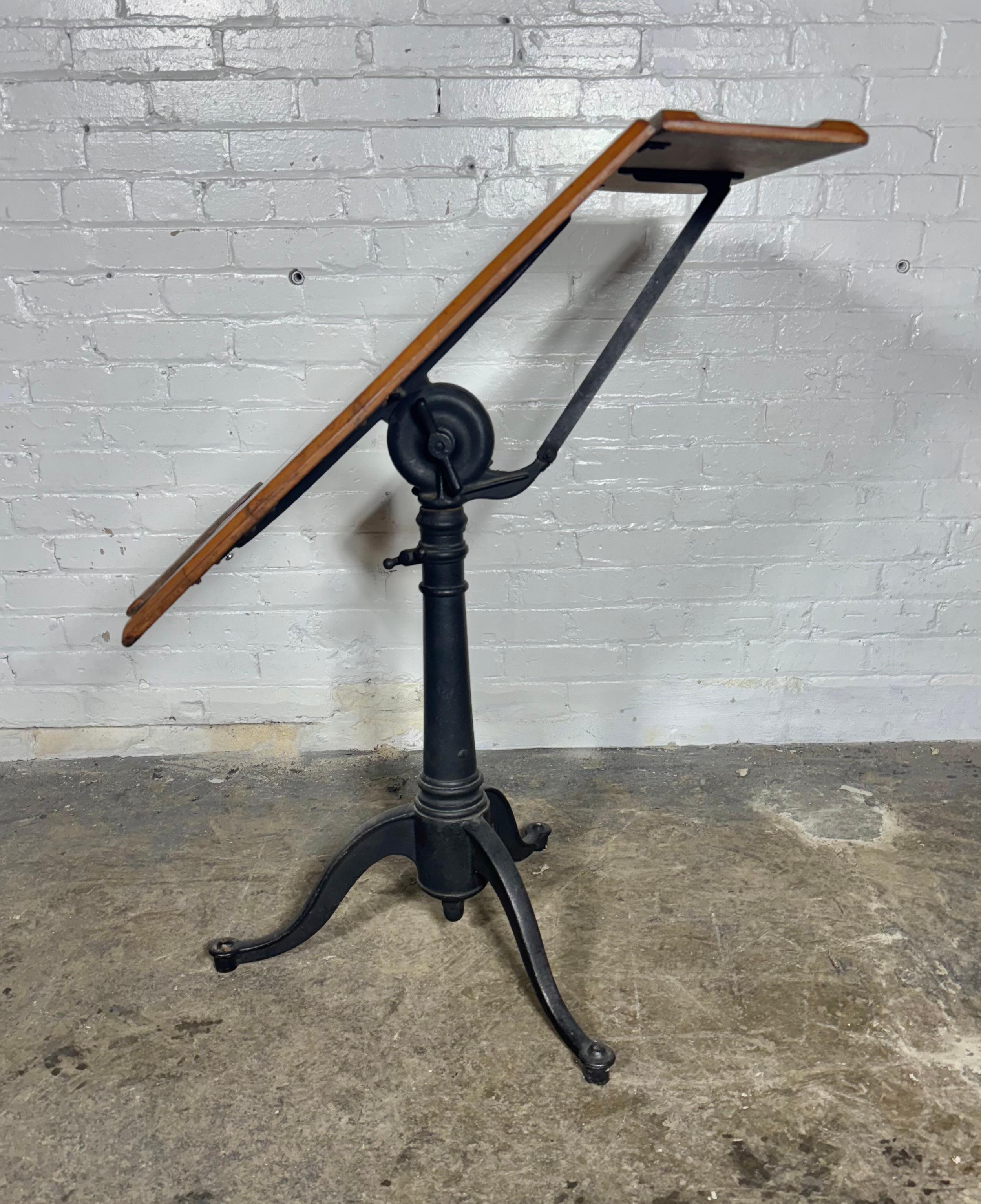 Antique Keuffel & Esser Drafting Table with Iron Base.. Adjustable height from 30 inches tall to 38 inches tall maybe a little bit more if you push it 24 inches wide original oak top.Retains its original finish .patina,  This table is perfectly