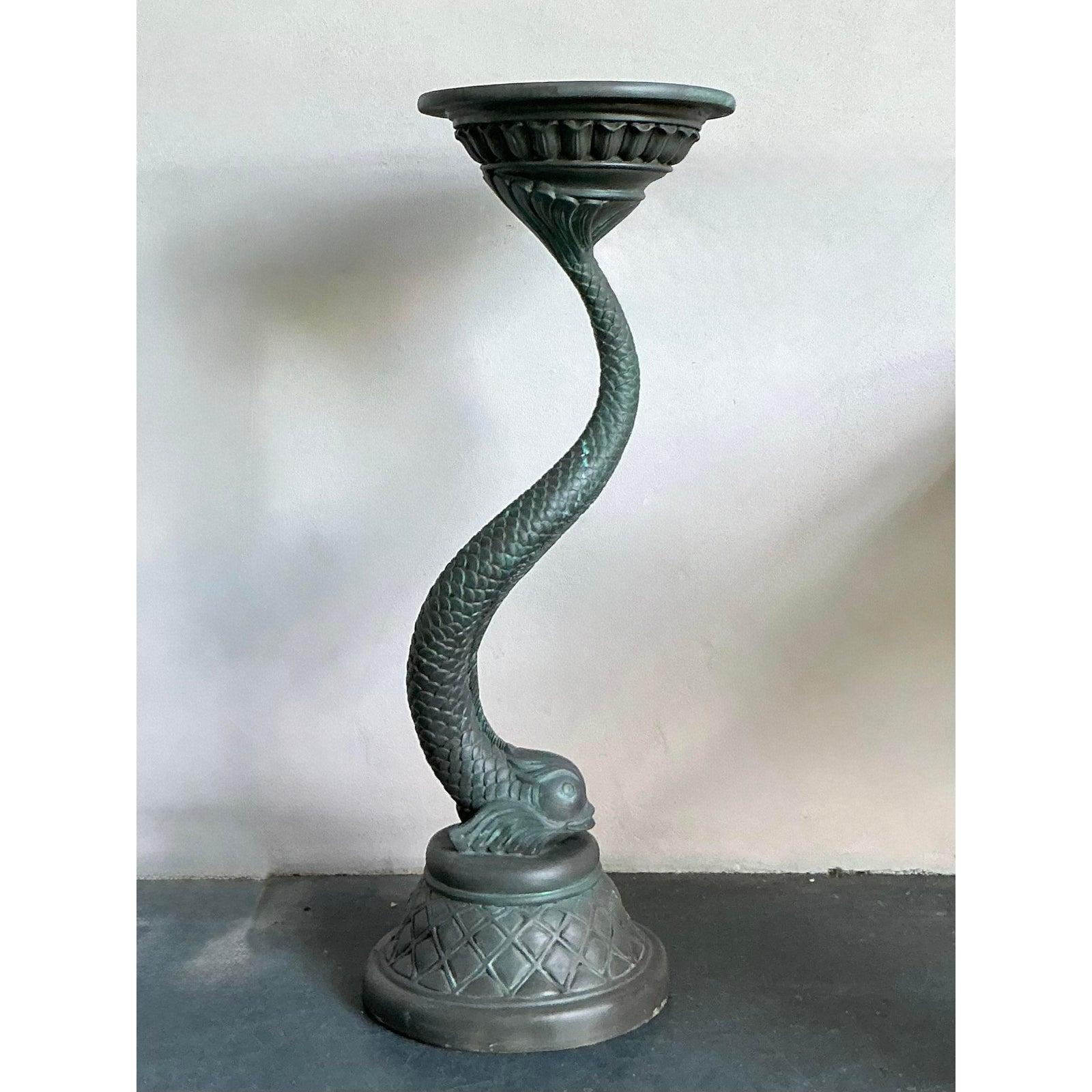 Introduce a captivating blend of artistry and functionality with this striking vintage cast resin koi pedestal. This unique piece features a beautifully sculpted koi fish, its body gracefully twisting to form the support for the circular tabletop.