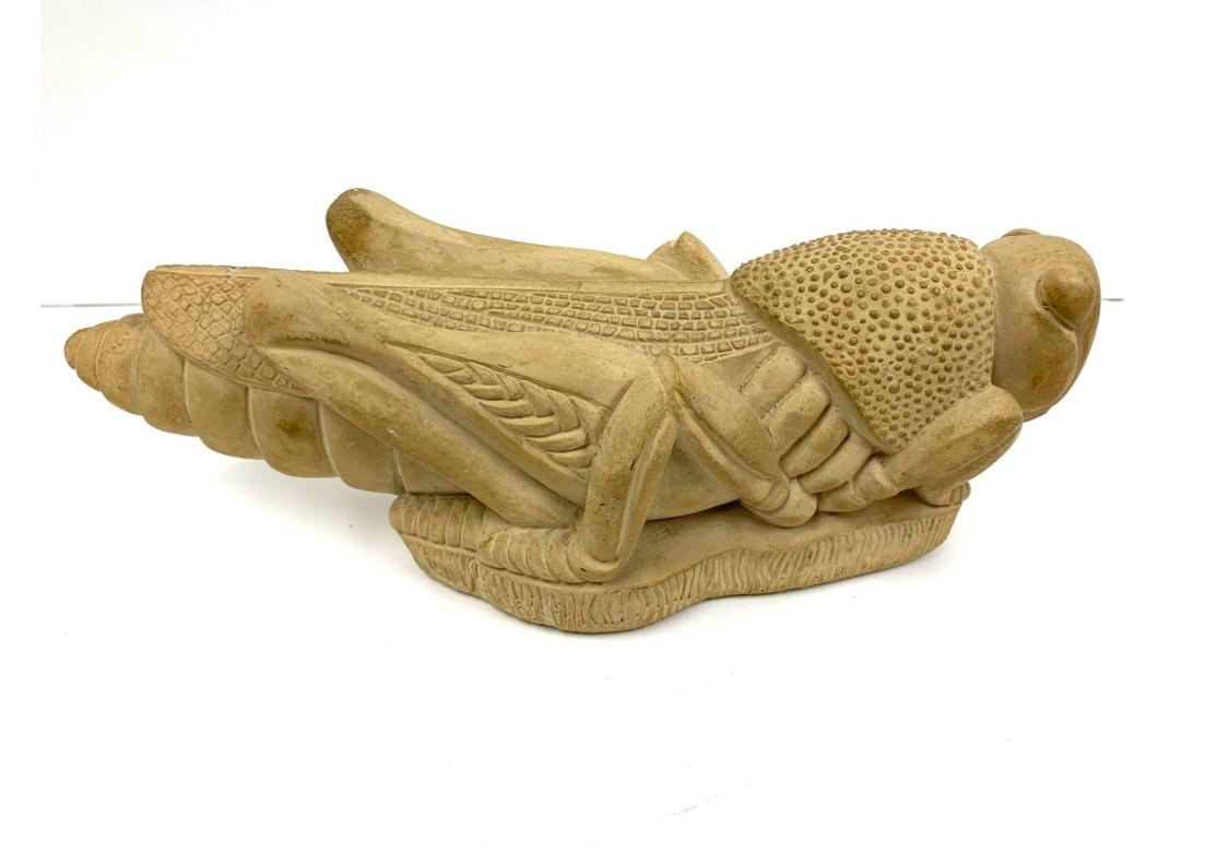 Cast stone grasshopper figure surmounted on a conforming plinth base, The grasshopper nicely detailed and textured in a sand color stain. Signed in mold and dated 1988.

Dimensions: 11 1/2