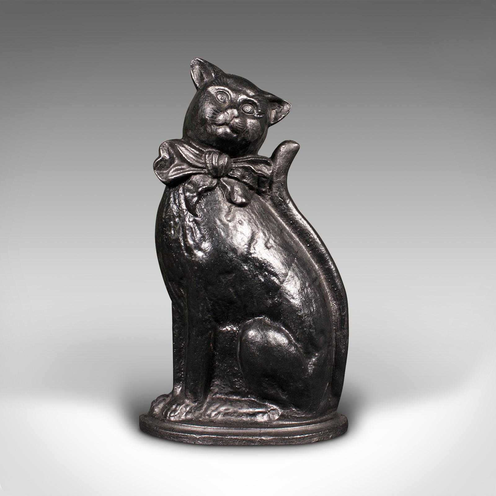 This is a vintage cat door stop. An English, cast iron decorative doorstopper, dating to the mid 20th century, circa 1950.

Invite this cheerful character into your home
Displays a desirable aged patina and in good order
Charmingly cast in