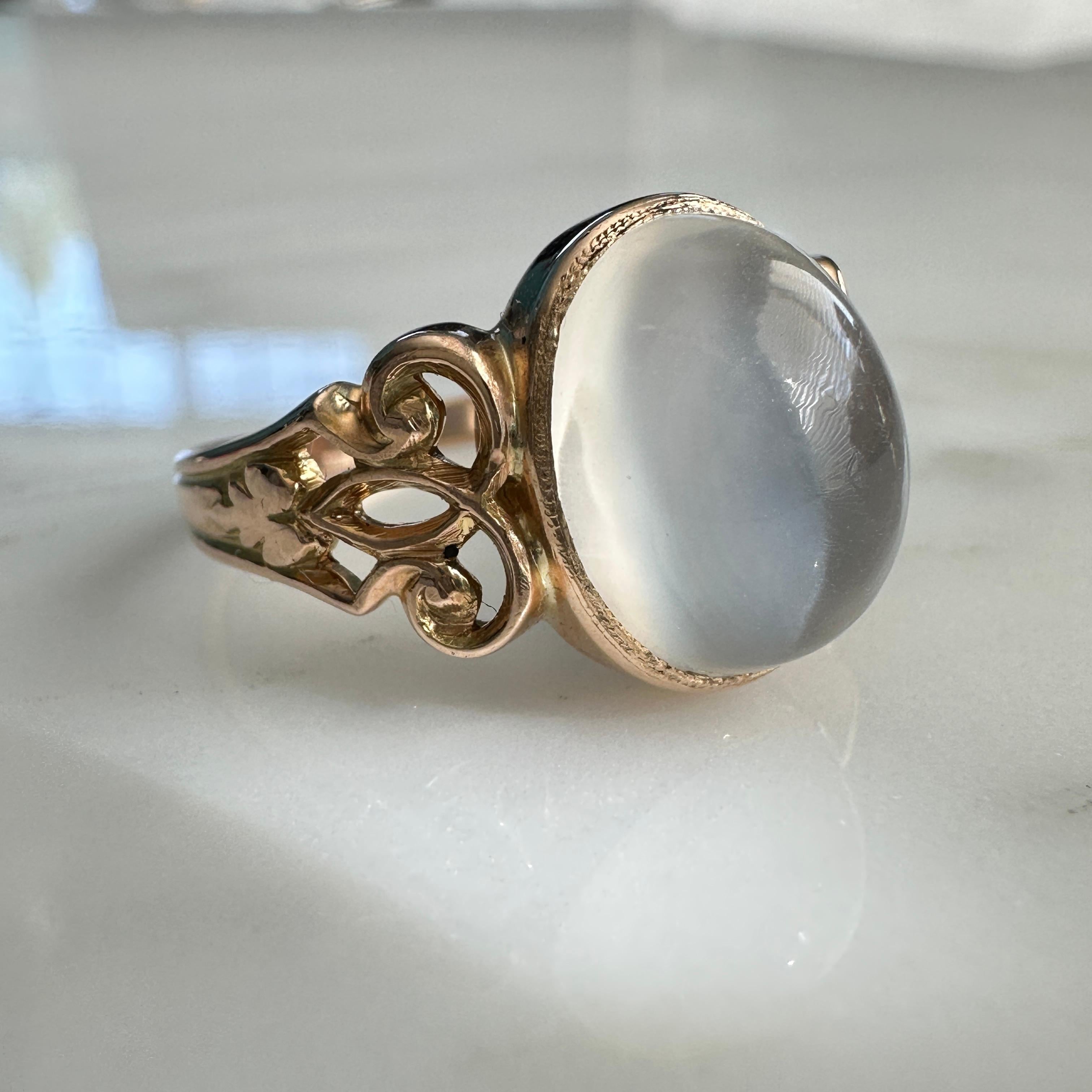 Details:
Fabulous vintage Cat's Eye Moonstone ring set in 14K yellow gold. The ring is 14K yellow gold, and has a lovely fleur-de-lis pattern on the shoulders of the setting. The cabochon moonstone is a nice size, measures 11.9mm x 9.59mm and has a
