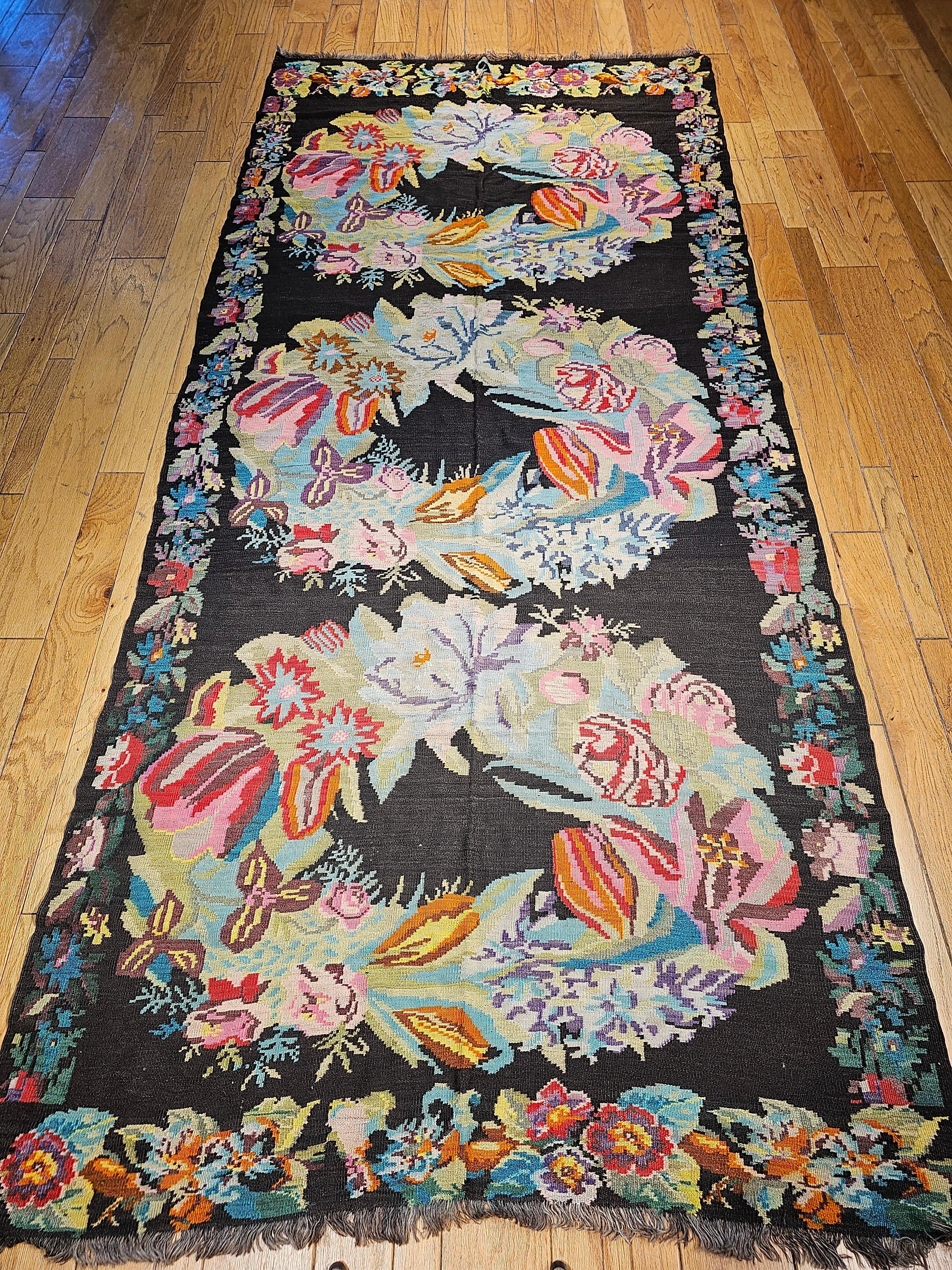 Vintage Caucasian Karabagh kilim in floral pattern from the early 1900s.  The Karabagh kilim has a floral pattern in the shape of three floral wreaths.  The color combination is truly fantastic. Three floral  wreaths in blues, red, green, yellow 