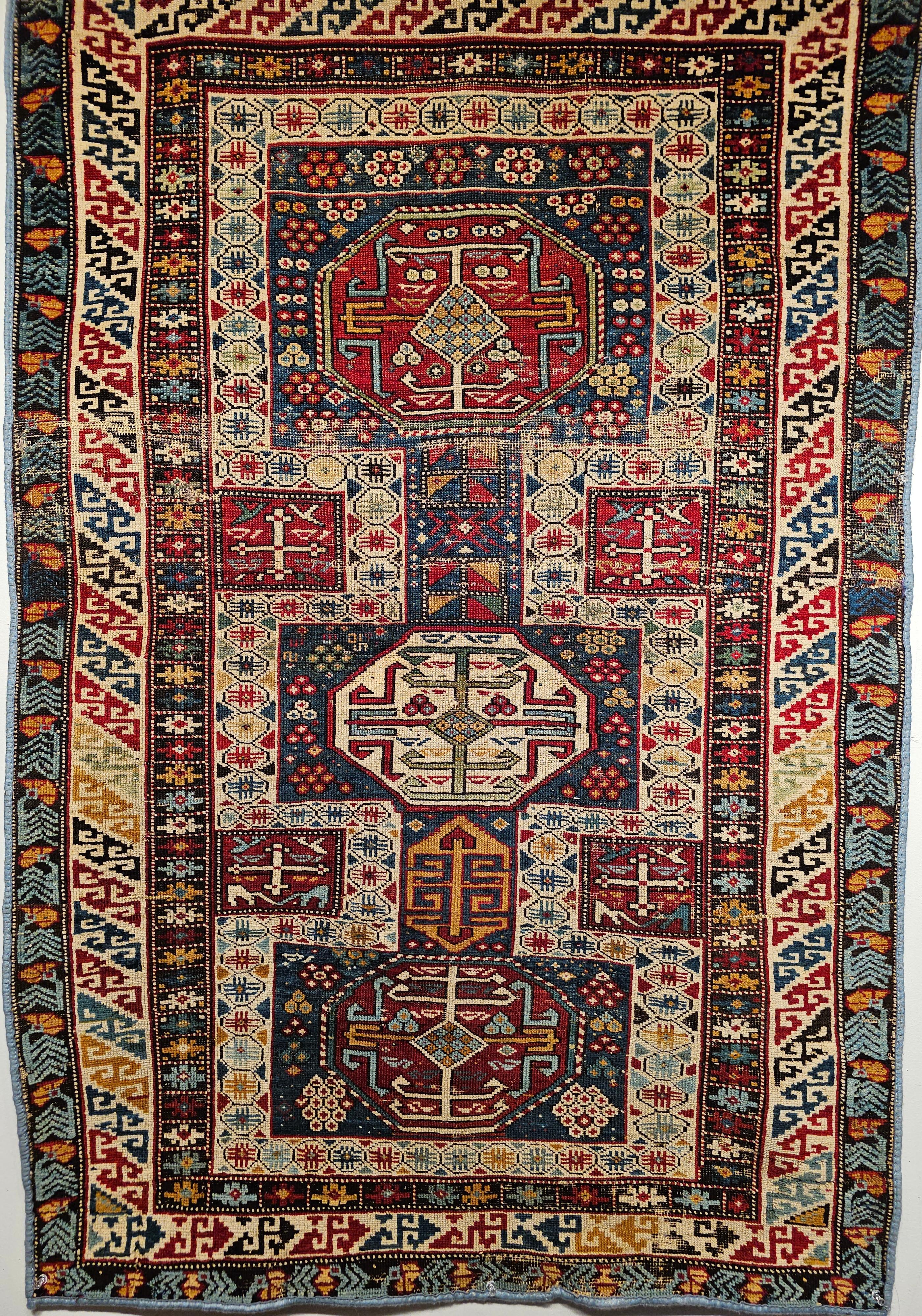 We love the fantastic design and color pattern in this early 1900s Caucasian Kuba area rug in French blue, red, yellow.  Kuba is a village located in the southeast area of Azerbaijan in the Caucasus.  The Kuba rug is in a triple medallion design in