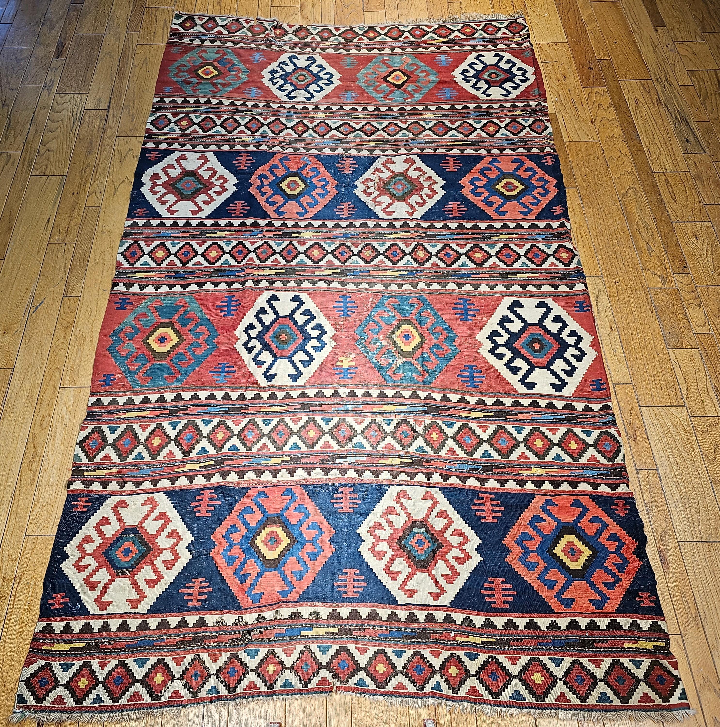 Kilim caucásico kazako del siglo XIX, tamaño habitación, en azul, verde, rosa, marfil, azul marino y amarillo.   Dado que los kilims son tejidos planos de tipo tapiz (sin pelo), es muy raro encontrar uno del tamaño de una habitación que tenga más de