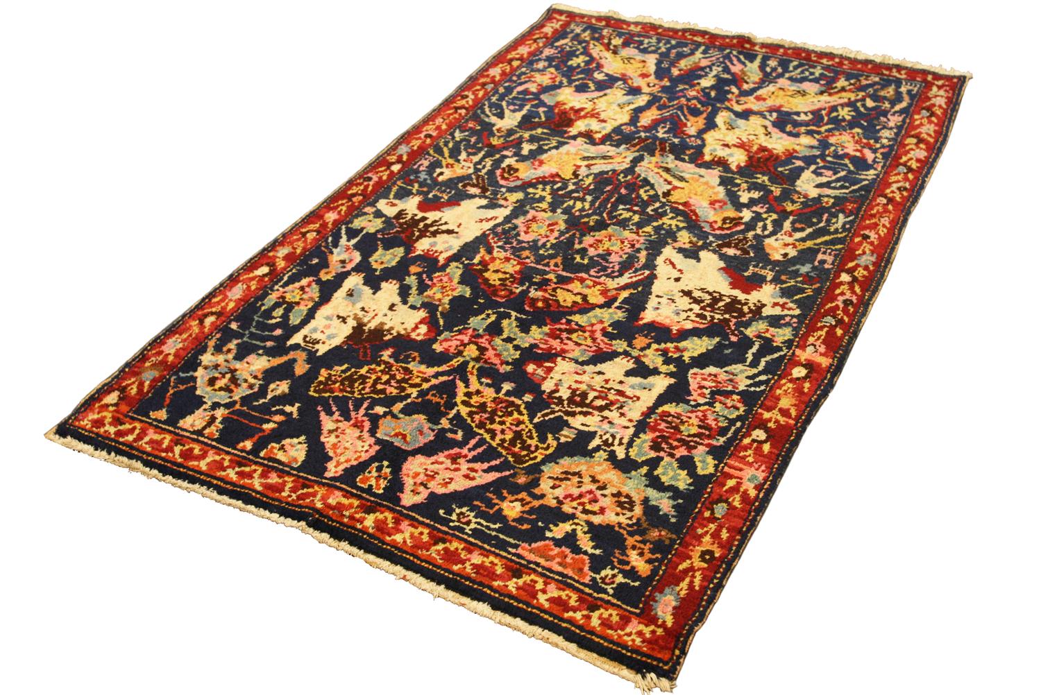The abrashed deep blue field with overall design of bold animal figures and large birds together with polychrome serrated palmettes, angular vine, small floral motifs and small stylised animal figures. In rust border of stylised floral motifs