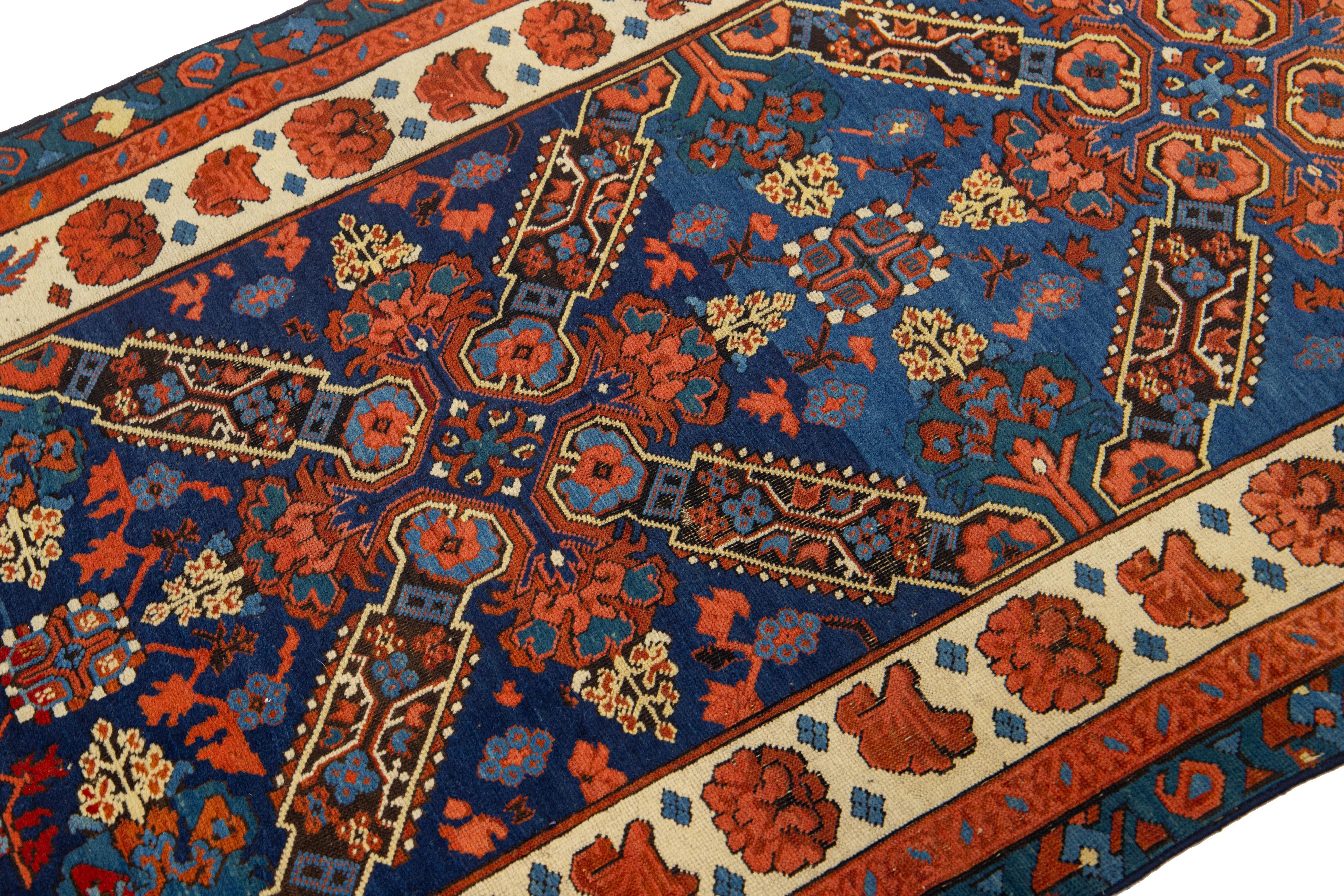 Dieser Wollteppich von Seychour wird in sorgfältiger Handarbeit hergestellt. Der Teppich ist in einem satten Marineblau gehalten, das mit zarten Verzierungen in verschiedenen Rot-, Grün-, Blau- und Beigetönen geschmückt ist und ein kompliziertes