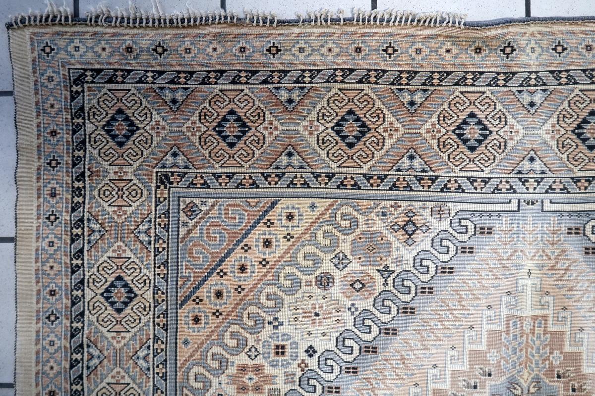 Dieses kaukasische Textil aus den 1950er Jahren zeigt ein Teppichmuster im Schirwan-Stil, das mit traditionellen geometrischen Mustern und Stammesmotiven aufwändig gewebt ist. Er ist aus dünnem Baumwollgewebe gefertigt und ahmt das Aussehen