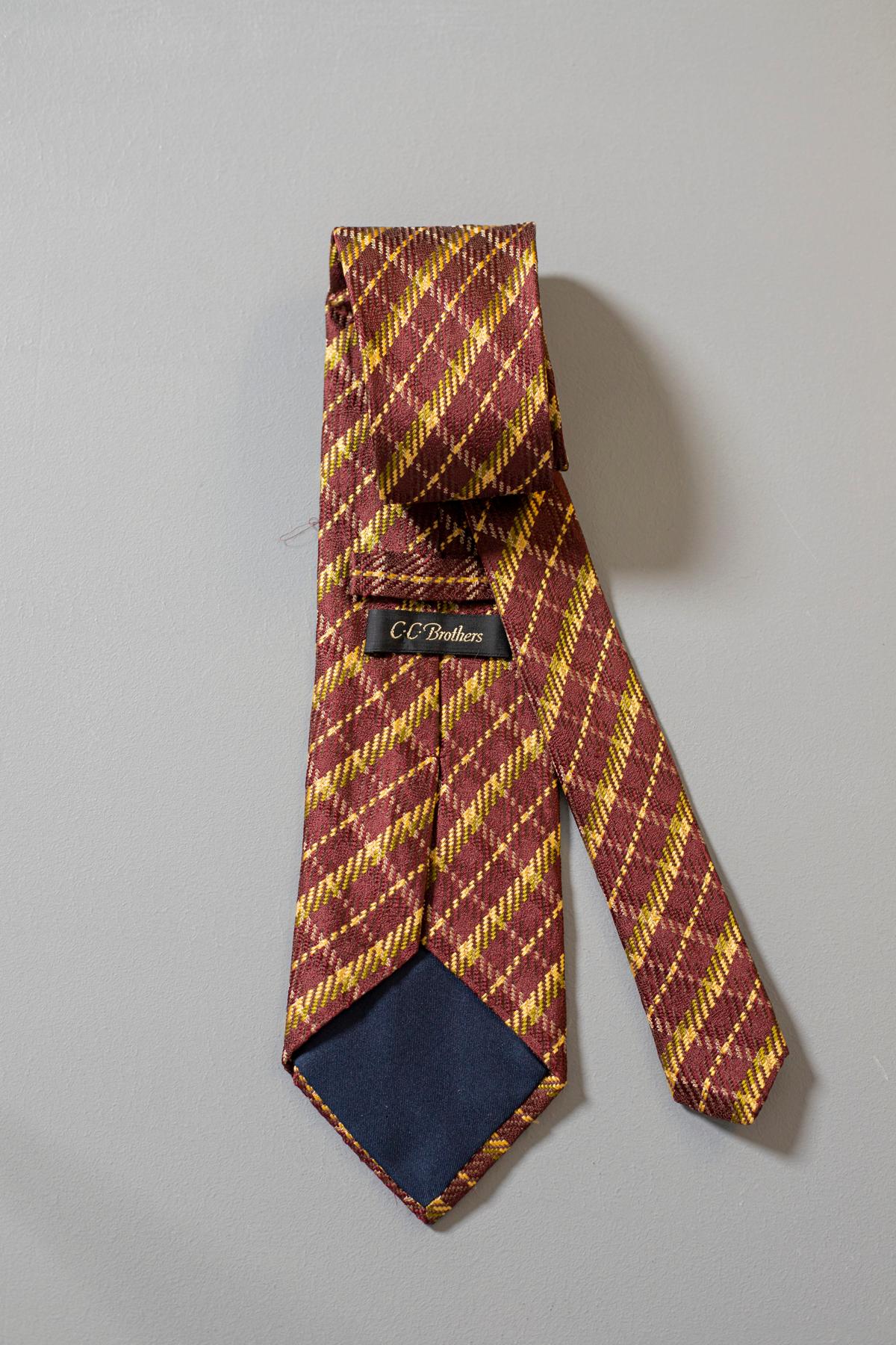Vintage C. C. Brothers tie, it is made in 100% silk. Decorated with yellow lines that form rhombuses, the main color is brown, which makes it a predominantly winter tie to combine with a solid color suit or even more sporty clothing. 
