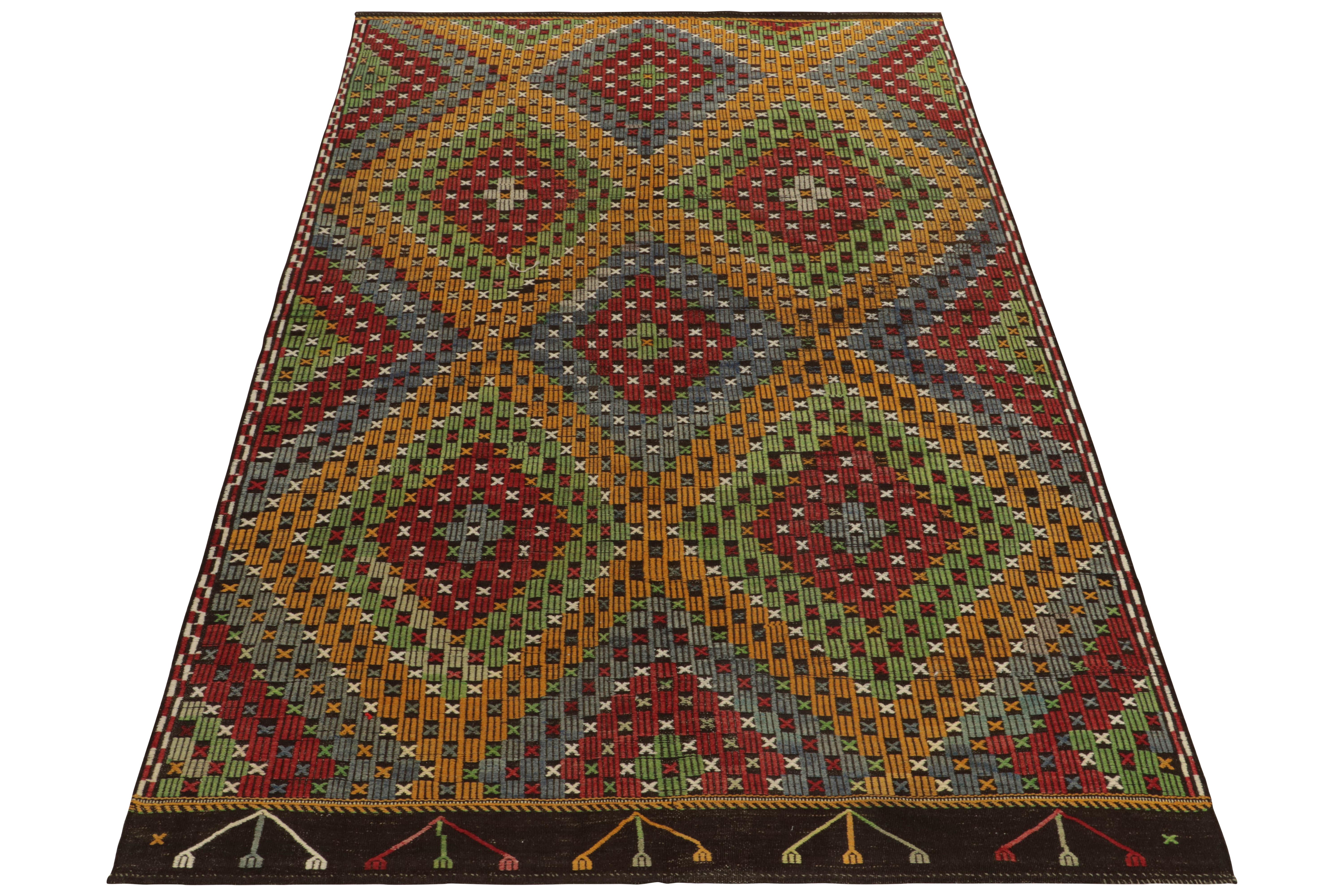 Connoting the celebrated Kurdish style, this 7x10 Cecim kilim rug hails from a special new curation of flat weaves. This vintage mid-century flatweave from Turkey features an embroidered diamond pattern alternating in tones of red, green, gold, blue