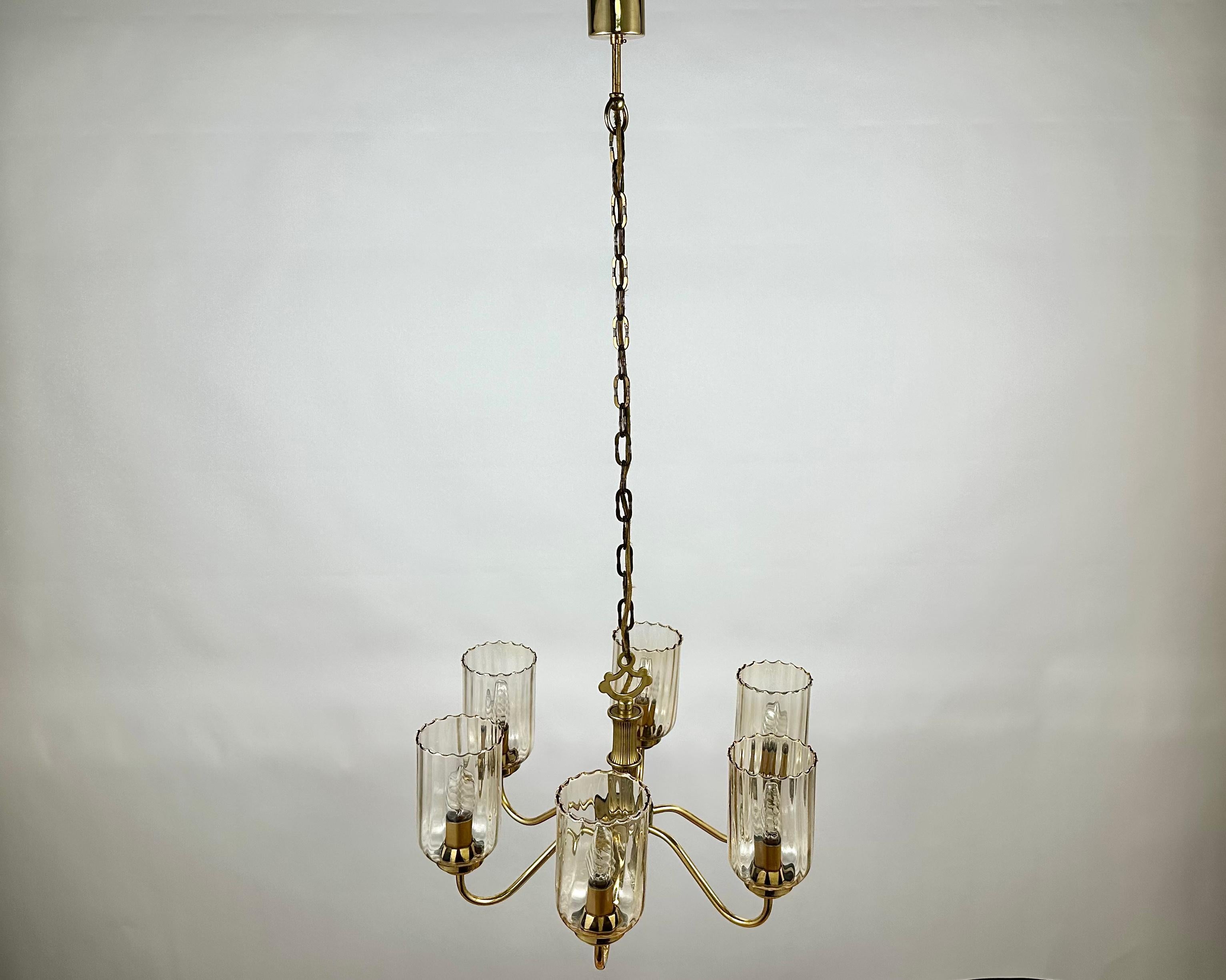 Schöne Vintage-Hängelampe, hergestellt in Deutschland, in den 1970er Jahren. 

Sechs Lampenschirme aus Glas, umrahmt von gealtertem Messing, wirken einerseits lakonisch, andererseits elegant.

Die Hauptfarbe des Modells ist Gold, das Material der