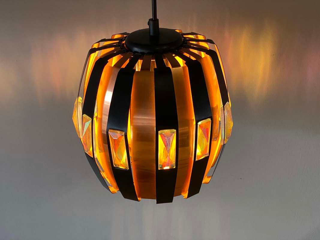 Special pendant lamp by designer Verner Schou for the Danish manufacturer Coronell Electro. The lamp is made of copper and black painted metal sheet on which iridescent prisms are applied. The glass prisms create a fascinating light effect