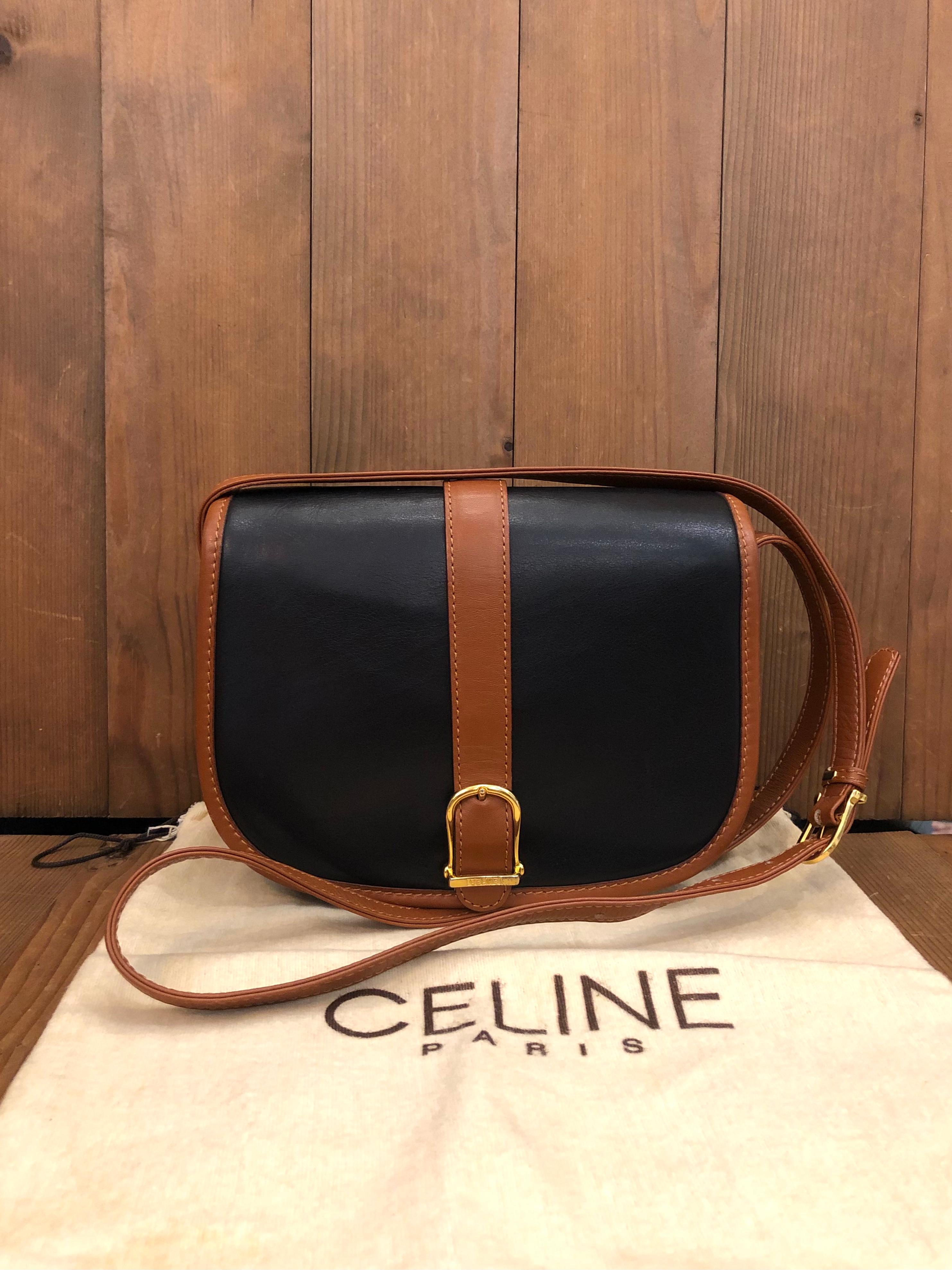 Vintage CELINE crossbody box bag in soft black leather trimmed with brown leather featuring an adjustable strap with one interior zip pocket and one back exterior open pocket. Front flap magnetic snap closure. Measures approximately  8 x 6 x 2