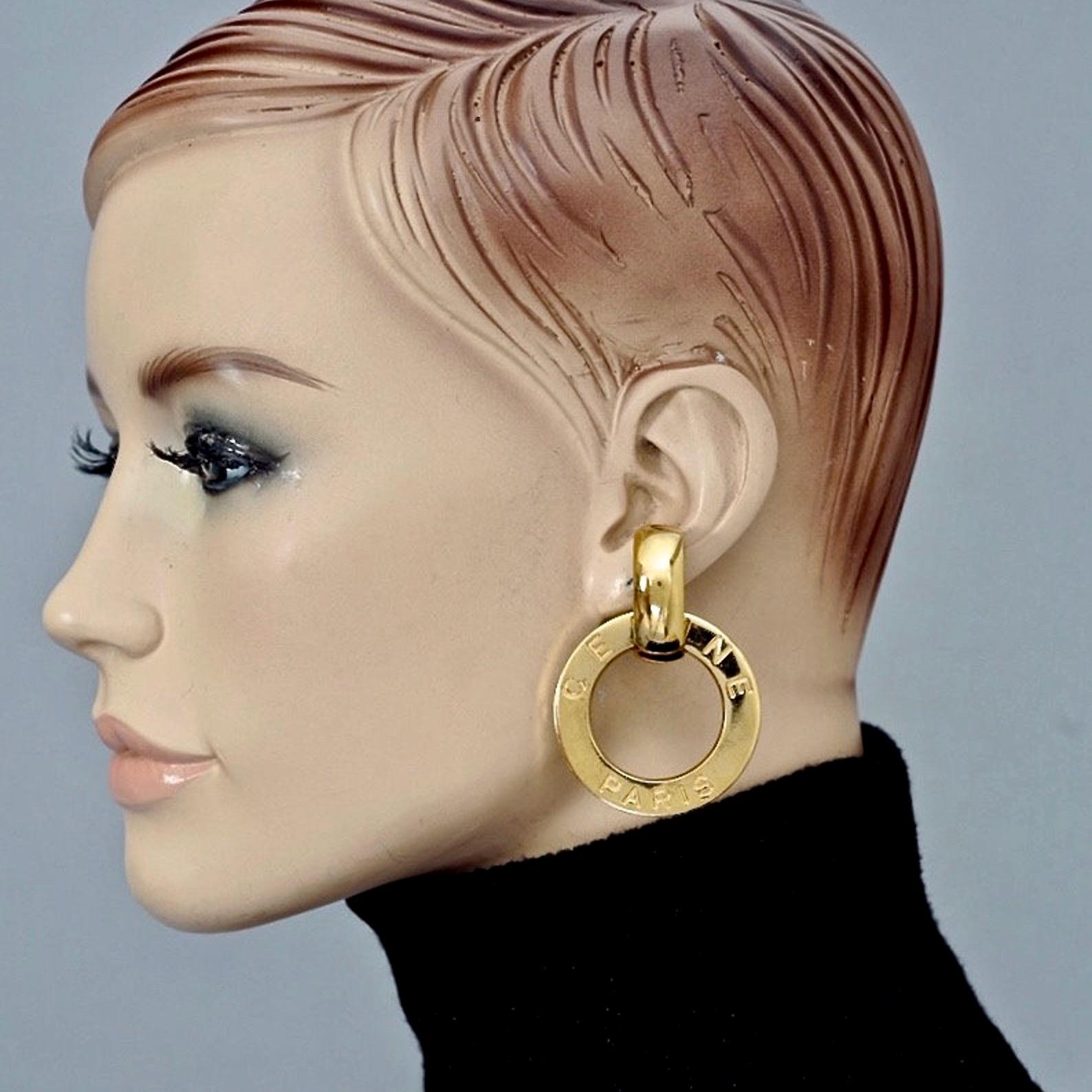 Vintage CELINE PARIS Logo Hoop Earrings

Measurements:
Height: 2.24 inches (5.7 cm)
Wearable Length: 1.61 inches (4.1 cm)
Weight per Earring: 32 gram

Features:
- 100% Authentic CELINE Paris.
- Dangling hoop earrings with engraved CELINE PARIS.
-