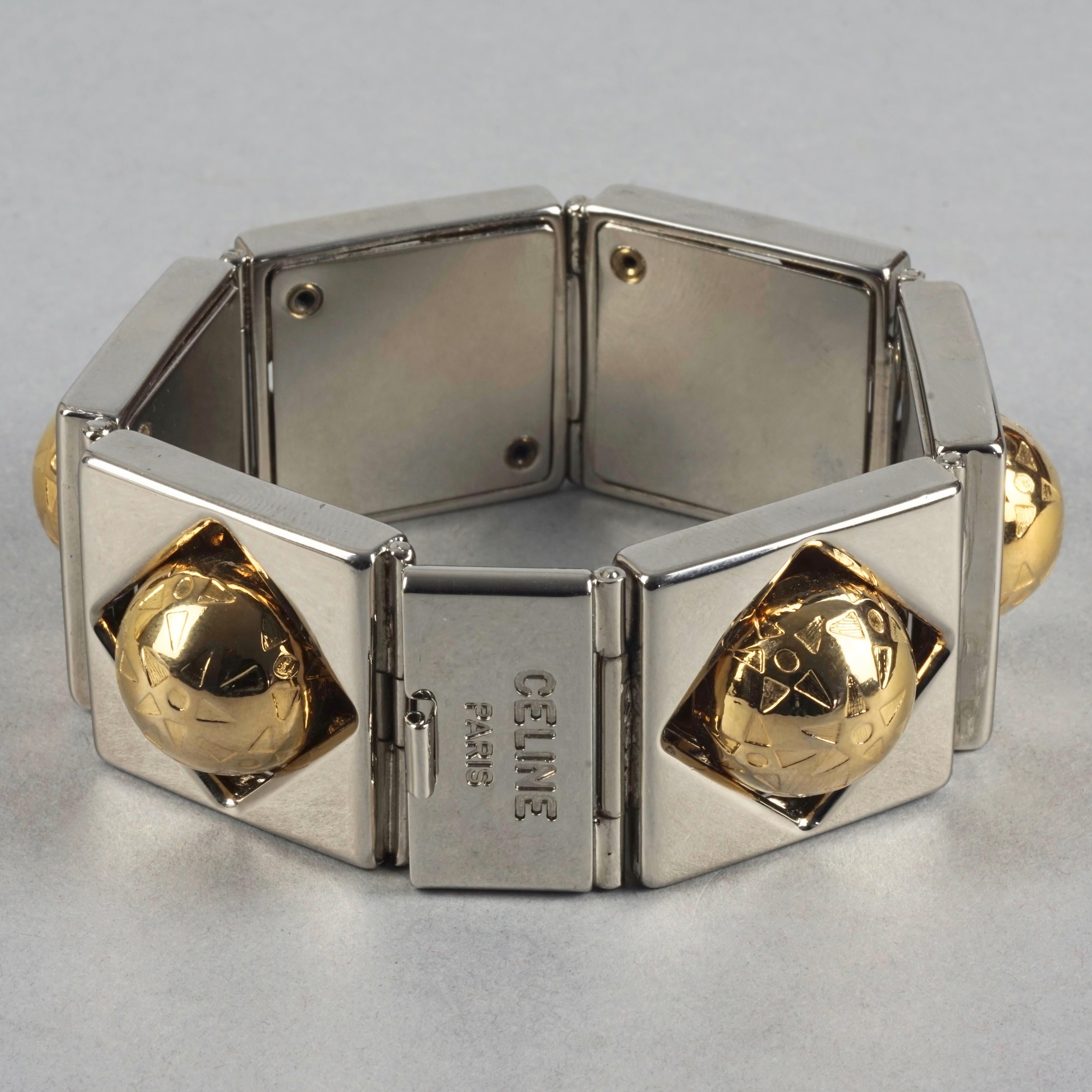 Vintage CELINE PARIS Planet Two Tone Link Bracelet

Measurements:
Height: 1.18 inches (3 cm)
Wearable Length: 7.28 inches (18.5 cm)
Depth: 0.55 inch (1.4 cm)

Features:
- 100% Authentic CELINE Paris.
- Chunky bracelet in gold and silver tone.
-