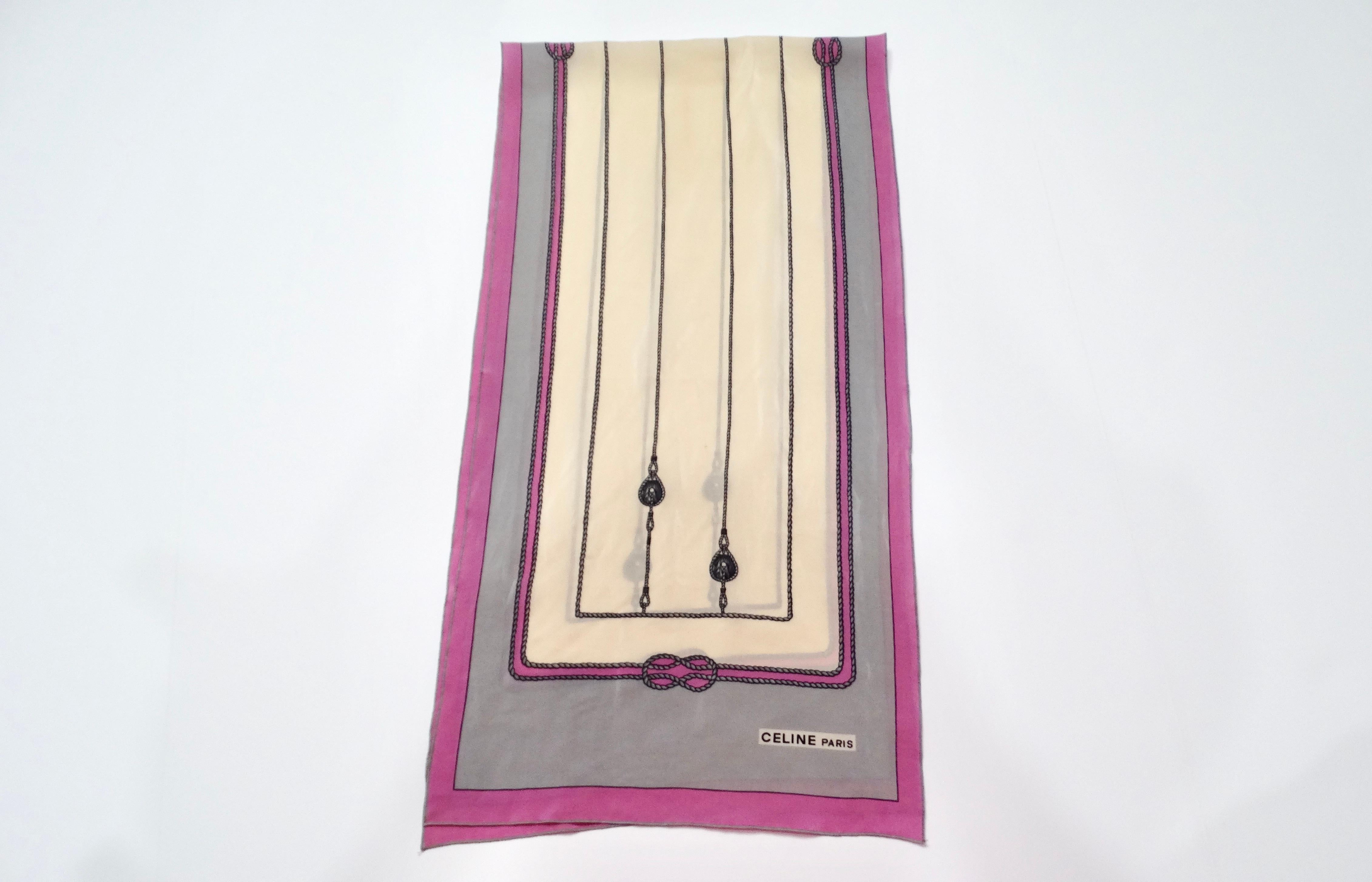 The Vintage Celine Rope & Pulley Motif Silk Scarf showcases a captivating blend of purplish-pink, grey, and cream hues. Its intricate rope and pulley print motif adds an artistic flair that reflects the timeless elegance associated with the Celine