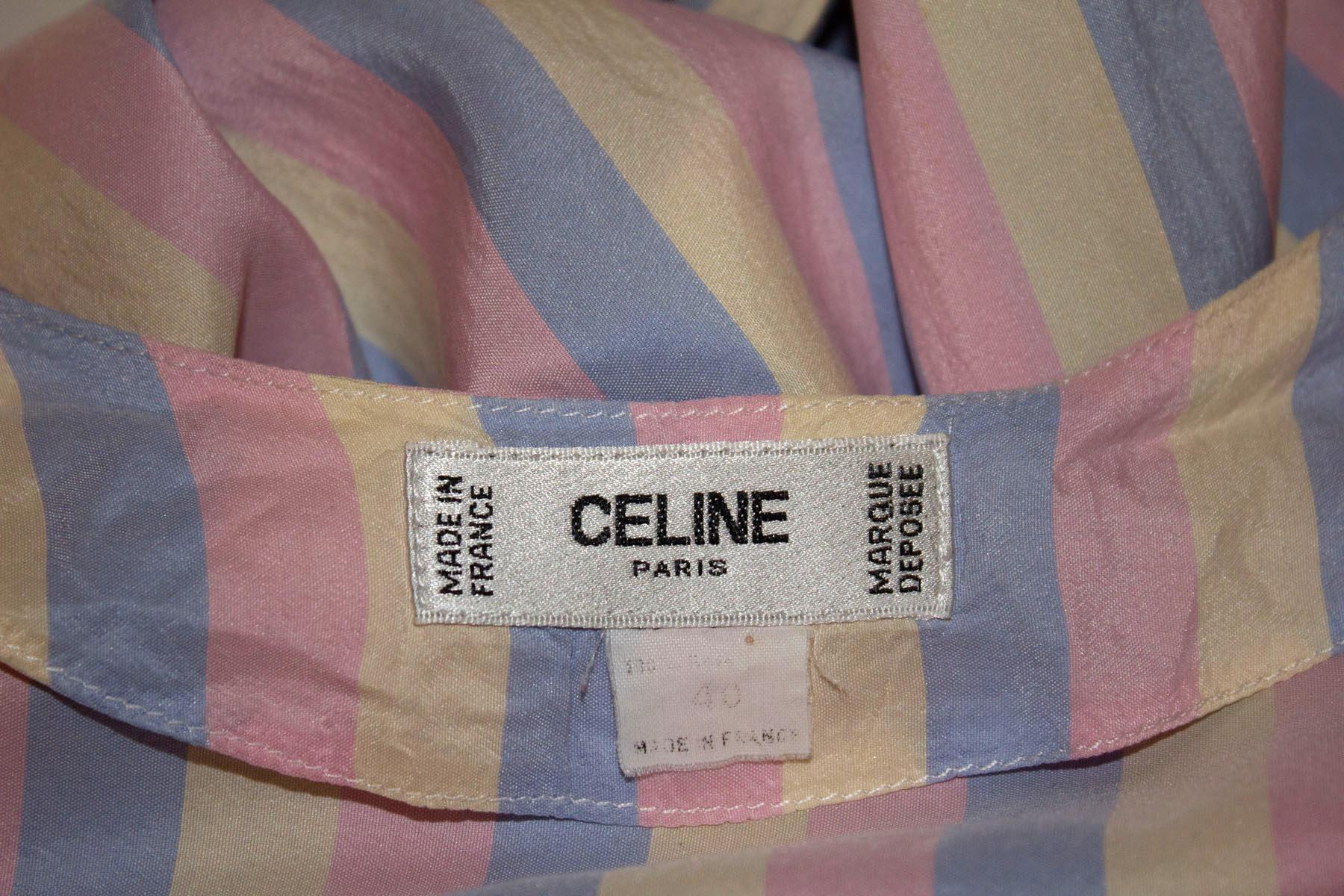 A wonderful vintage silk blouse by Celine , ideal for Spring / Summer.  The blouse is in super soft silk, is collarless, and has a pretty mix of pink, blue and white stripes.  It has single button cuffs, and a front button opening.  All the buttons