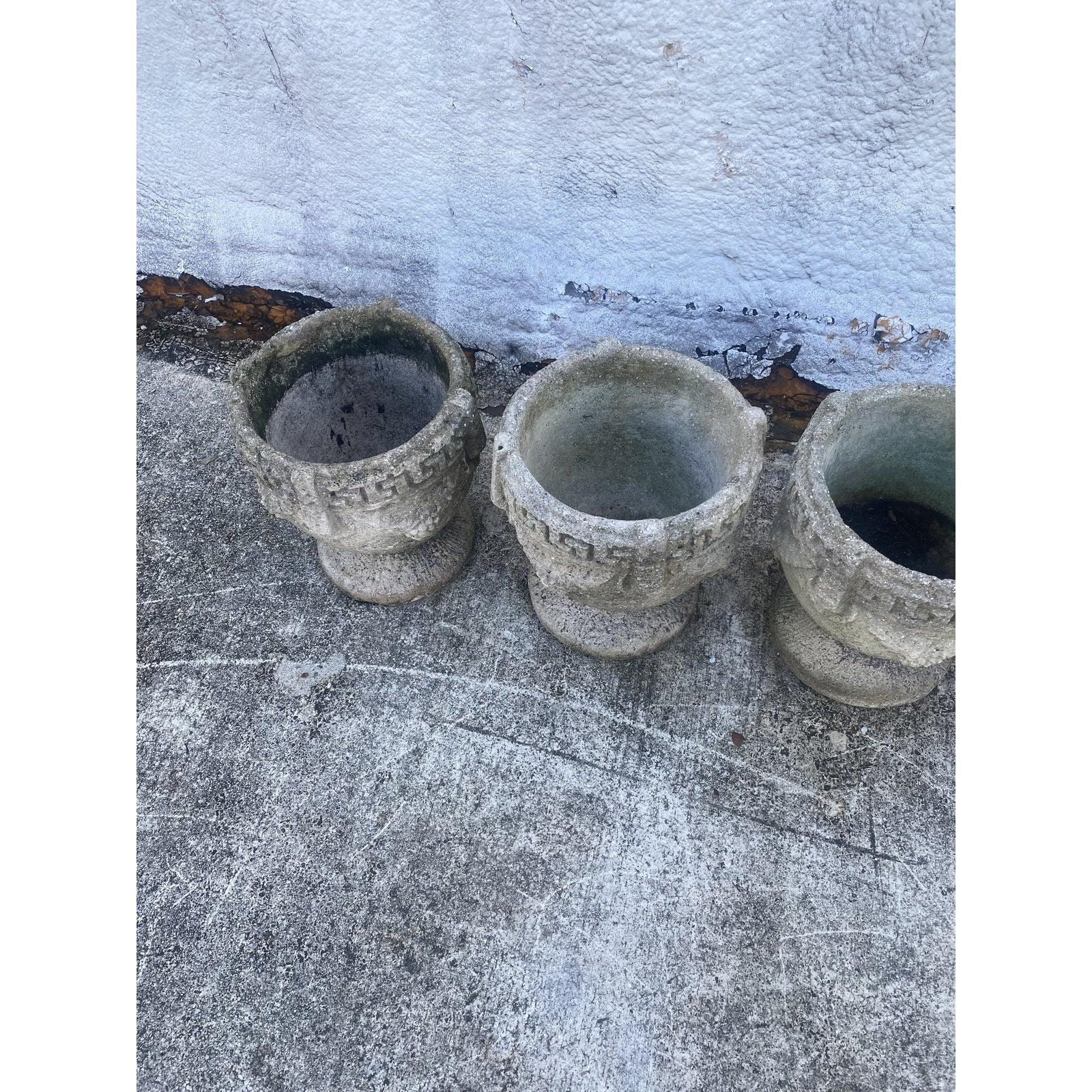 Fantastic set of four vintage cement planters. Beautiful Greek Key design with grape clusters. Beautiful patina from the passage of time. Acquired from a Palm Beach estate.