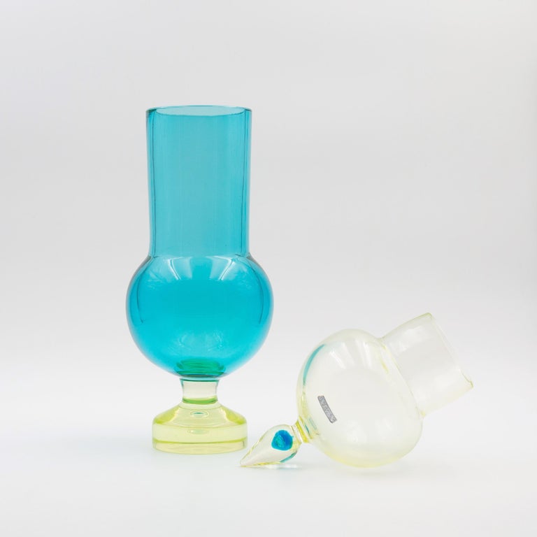 A vintage Cenedese Antonio da Ros Murano blown glass covered inspired by the shape of pharmacy jar.
The base is made from Uranium glass with blue body, a blue accent in the cover of the vase.
Vase is huge 46 cms high.

We are located in Belgium,