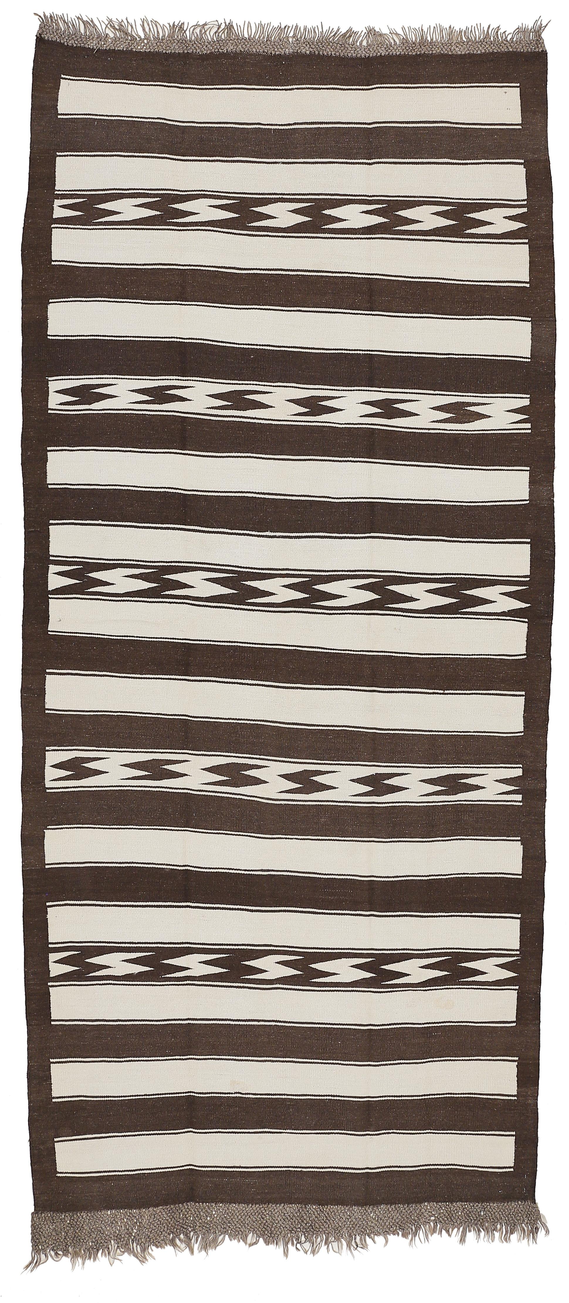 A rare flat-weave from the Uzbek tribes of Central Asia woven with natural, undyed wools with a pattern composed of horizontal dark brown stripes alternated at irregular intervals with an eye-dazzler, flame pattern.
This stunning, visual kilim is in