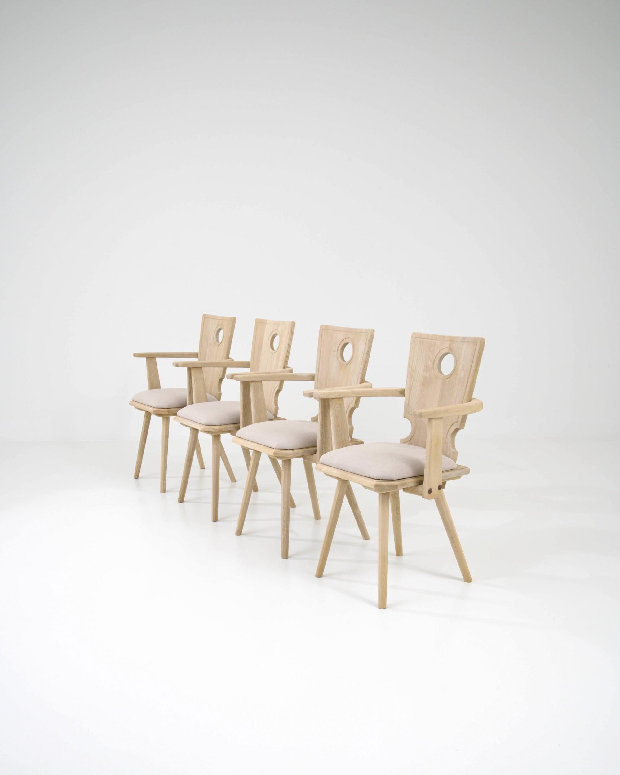 A pale hue and refined country silhouette give this vintage set of four wooden dining chairs a homey, serene character. Made in Central Europe in the 20th century, the form is inspired by traditional farmhouse chairs — with a touch of the