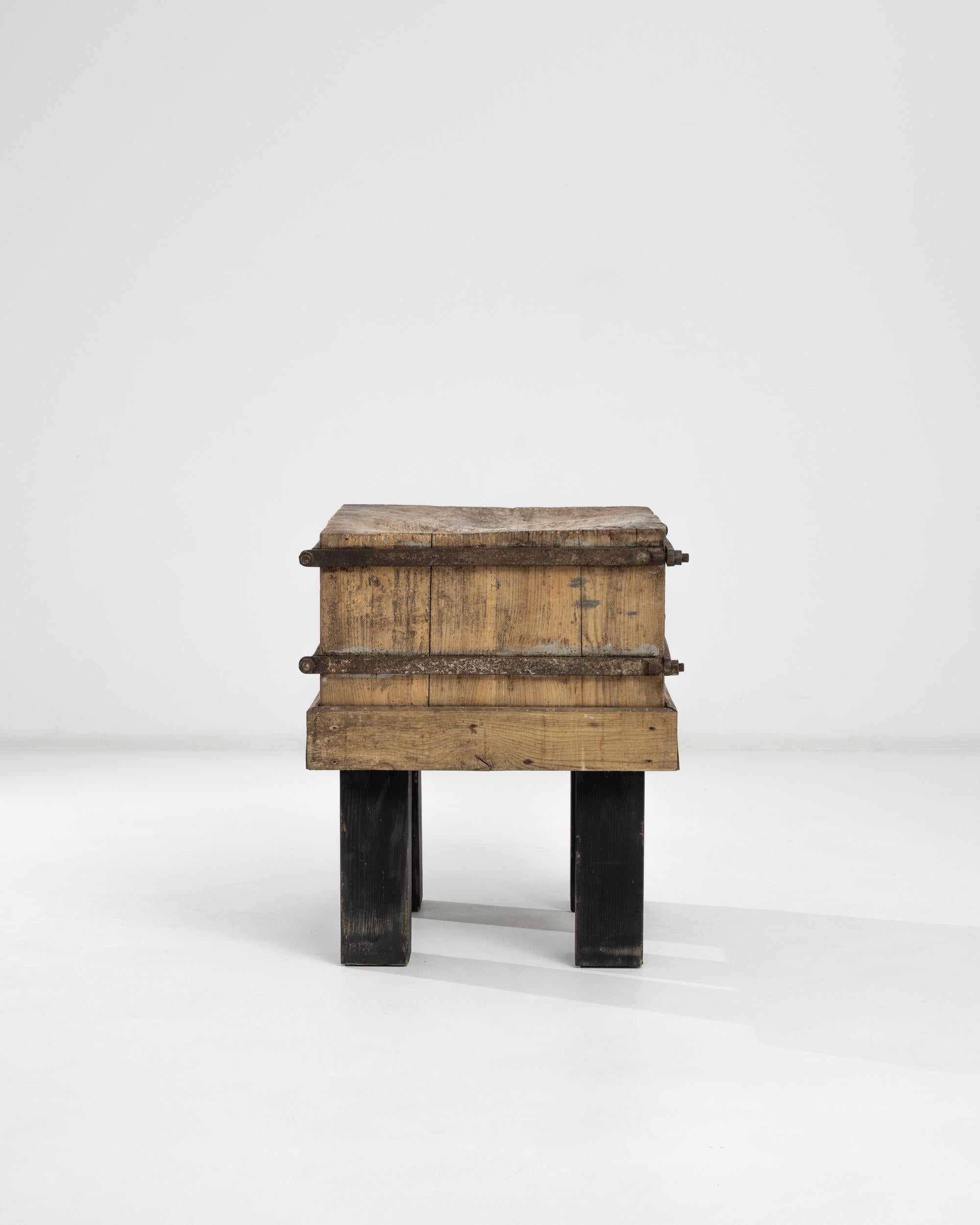 Raw wood, in combination with coarse metal elements, accentuates the brutalist spirit of this vintage work table made in Central Europe. The square black-painted legs bring a vivid sense of gravitation, affirming the powerful geometry of this unique