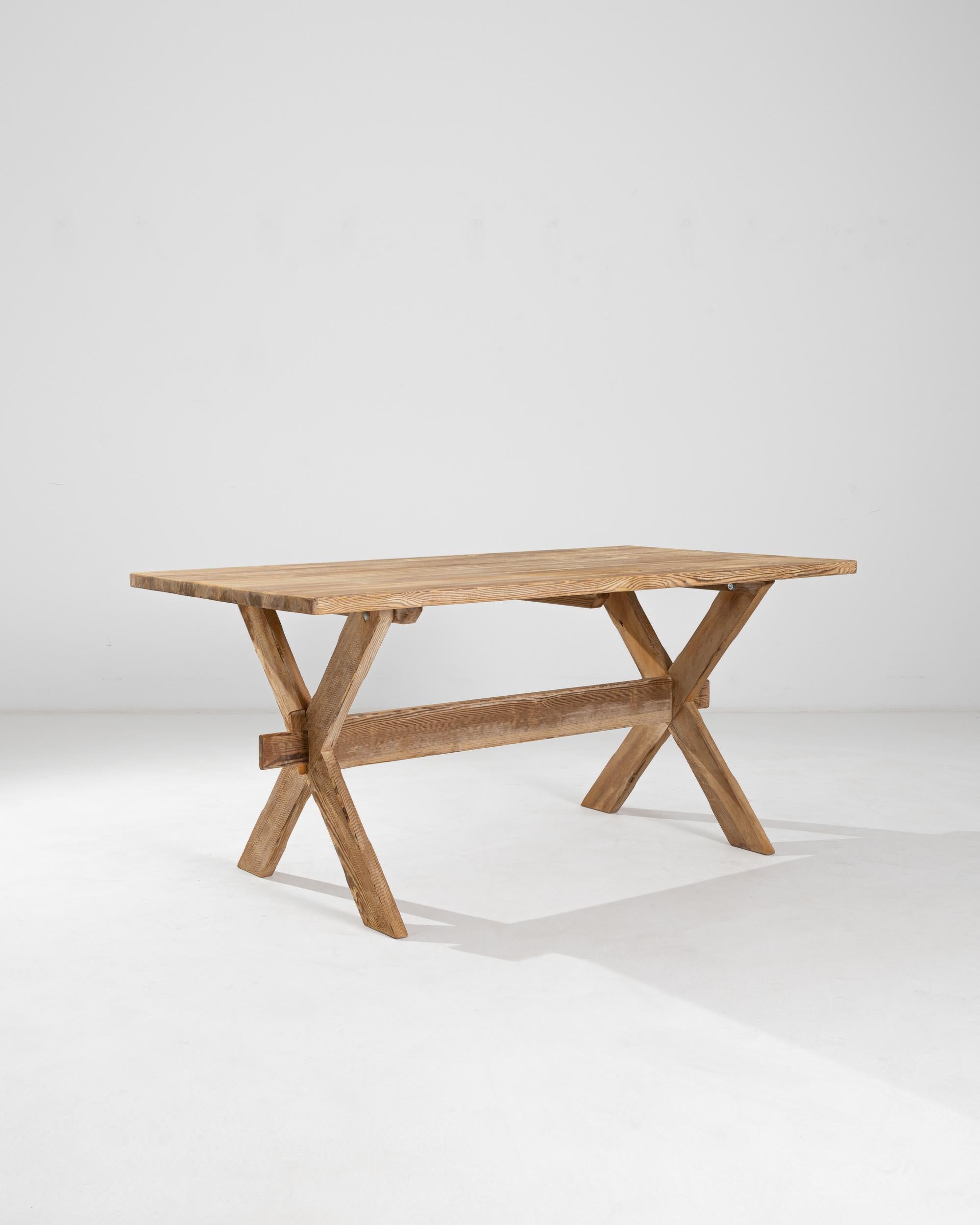 The simplicity and warmth of this vintage wooden table brings to mind the iconic designs of Scandinavian Modernism. Made in Central Europe in the 20th century, the silhouette is similar to that of an outdoor picnic table, evoking the savor of a meal