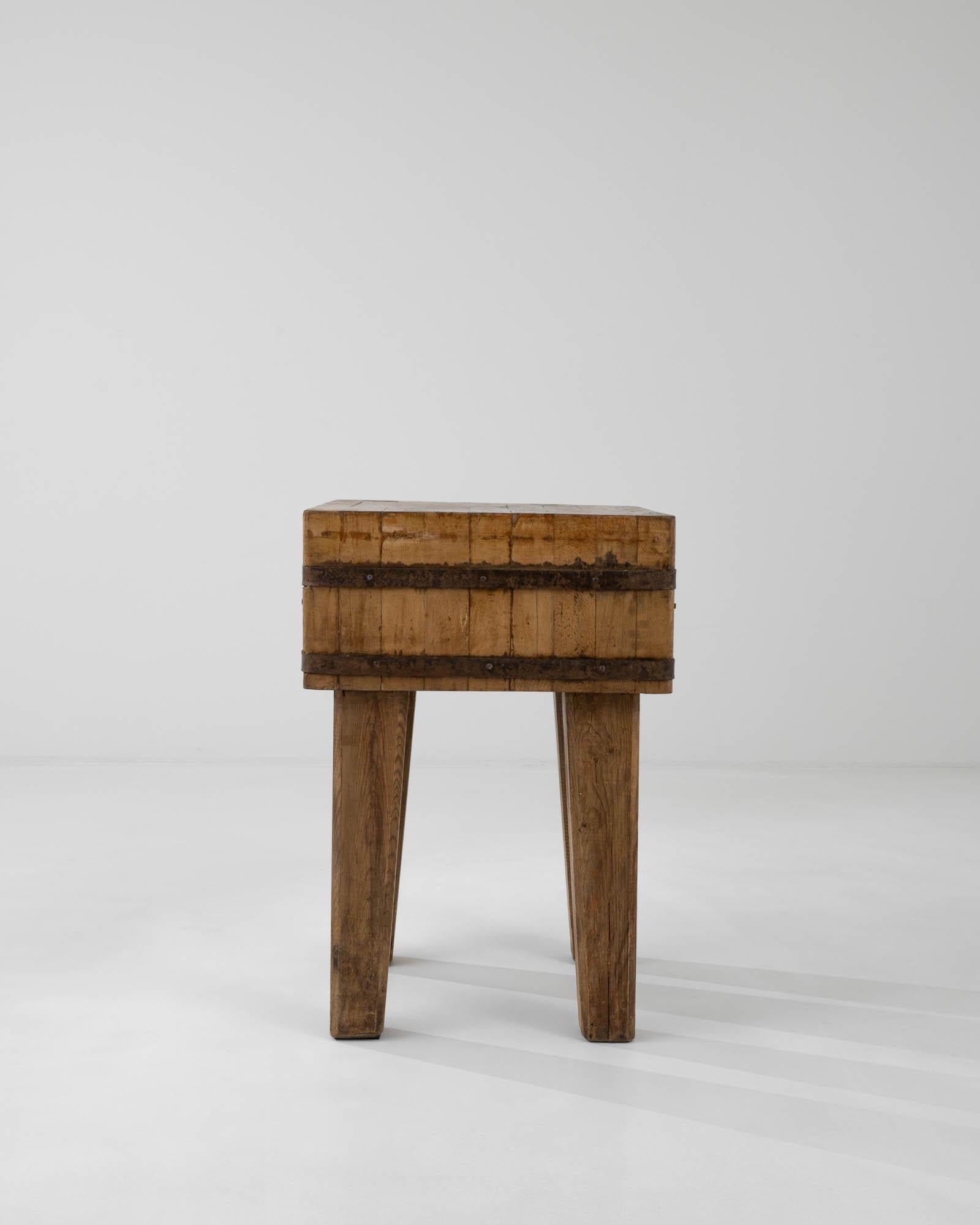 Raw wood, in combination with rustic metal elements, accentuates the brutalist spirit of this vintage work table, made in Central Europe. The thick top is formed from block of laminated hardwood pieces faced with the engrian upwards, a design