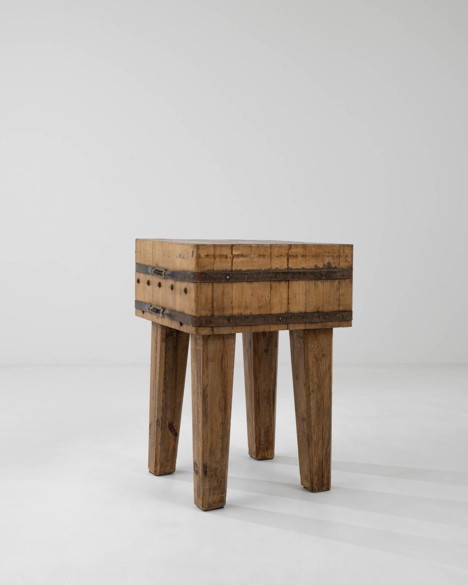 Raw wood, in combination with rustic metal elements, accentuates the brutalist spirit of this vintage work table, made in Central Europe. The thick top is formed from a block of laminated hardwood, pieces faced with the engrian upwards– a design