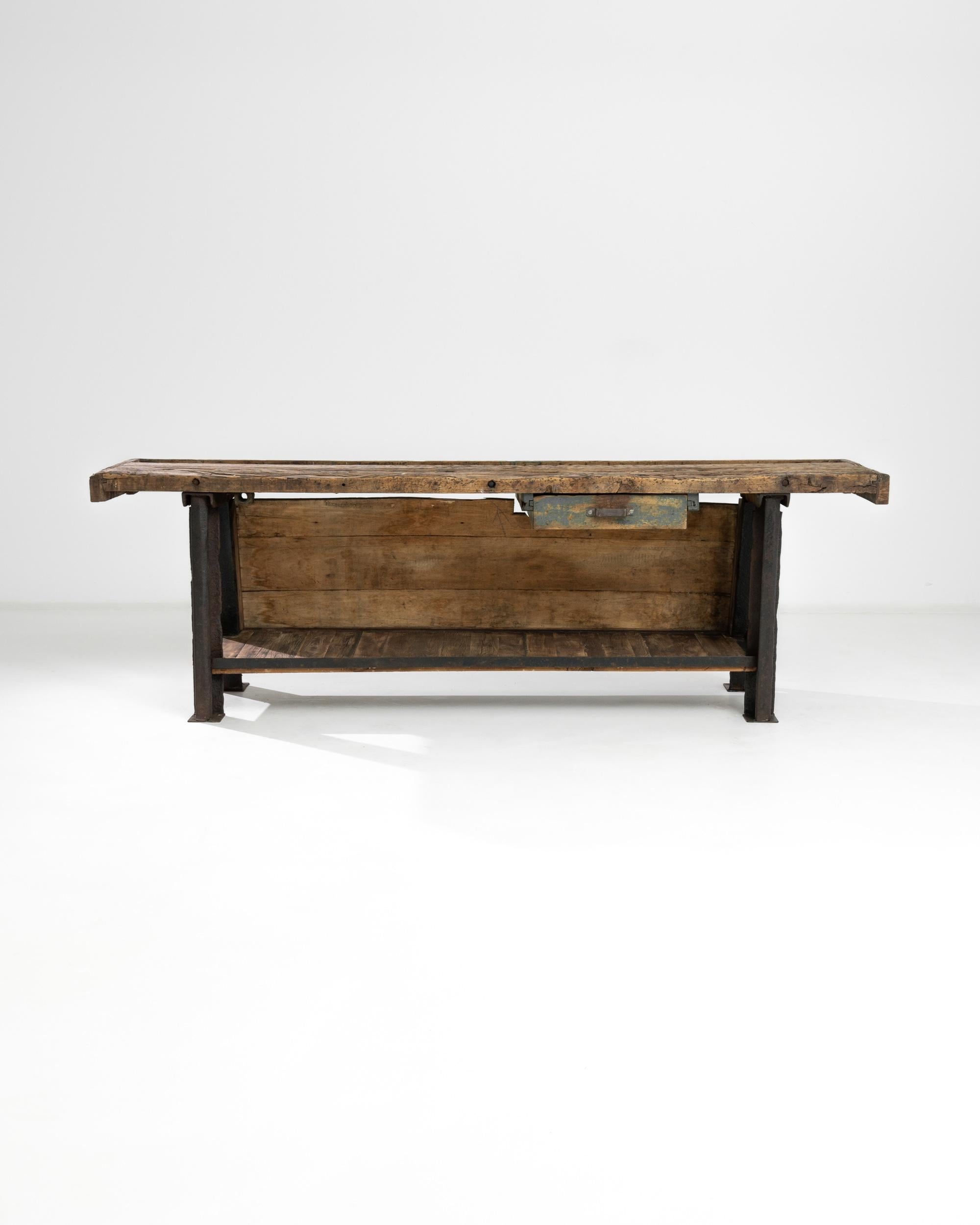 A metal table with wooden top from Central Europe, produced during the 20th Century. With a heavy iron frame, flanked on both sides with a slanted “A” shape, this work table will add an element of industry to any interior. A long working surface,