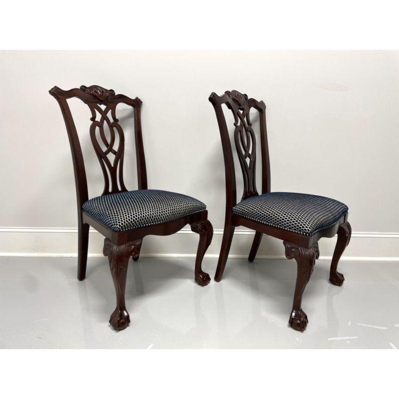 A pair of Chippendale style dining side chairs by Century Furniture. Solid mahogany with carved shell crest rails, carved backs, dark blue polka dot fabric upholstered seats, carved acanthus leaf to knees, cabriole legs and ball in claw feet. Made