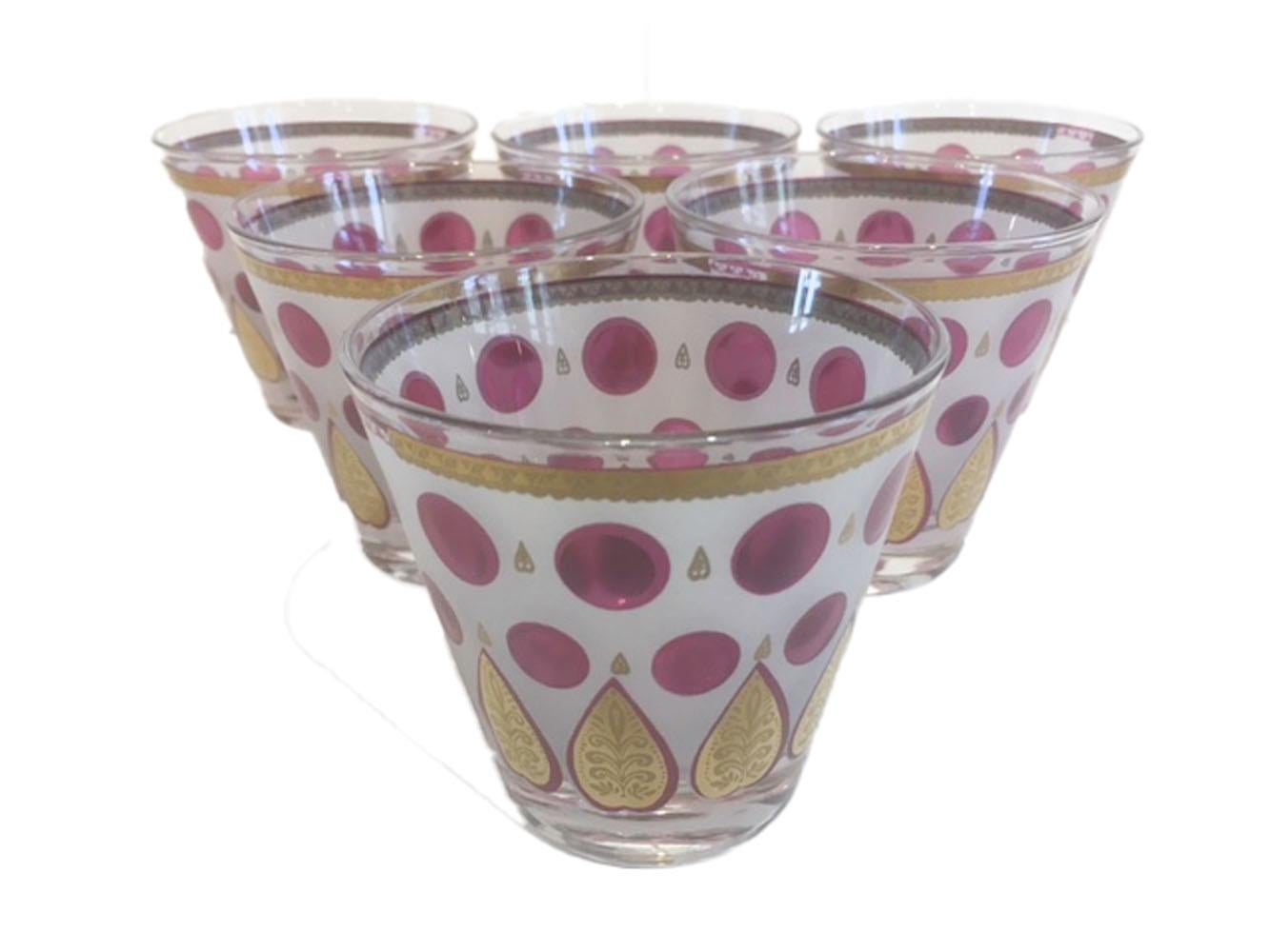 Rare set of Fred Press old fashioned glasses with translucent raspberry enamel dots below a gold band on a white ground all above a row of gold palmettes embossed with a stylized leaf pattern. All in excellent condition.