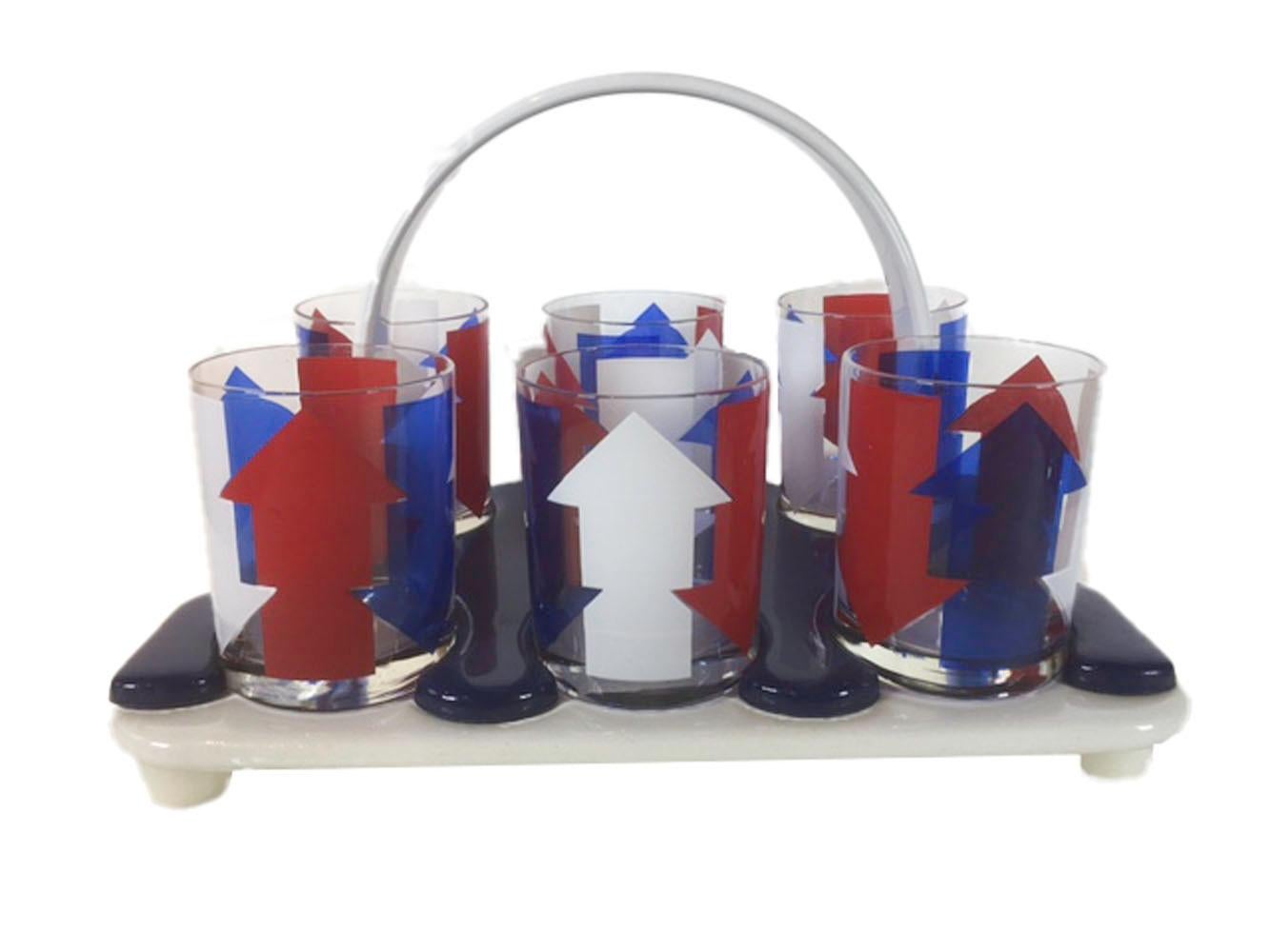 Midcentury eleven piece bar suite with vinyl caddy and ice bucket. All decorated with vertical red, white and blue arrows alternately pointed up and down. The set includes 6 large rocks glasses which fit into the blue and white vinyl caddy, a