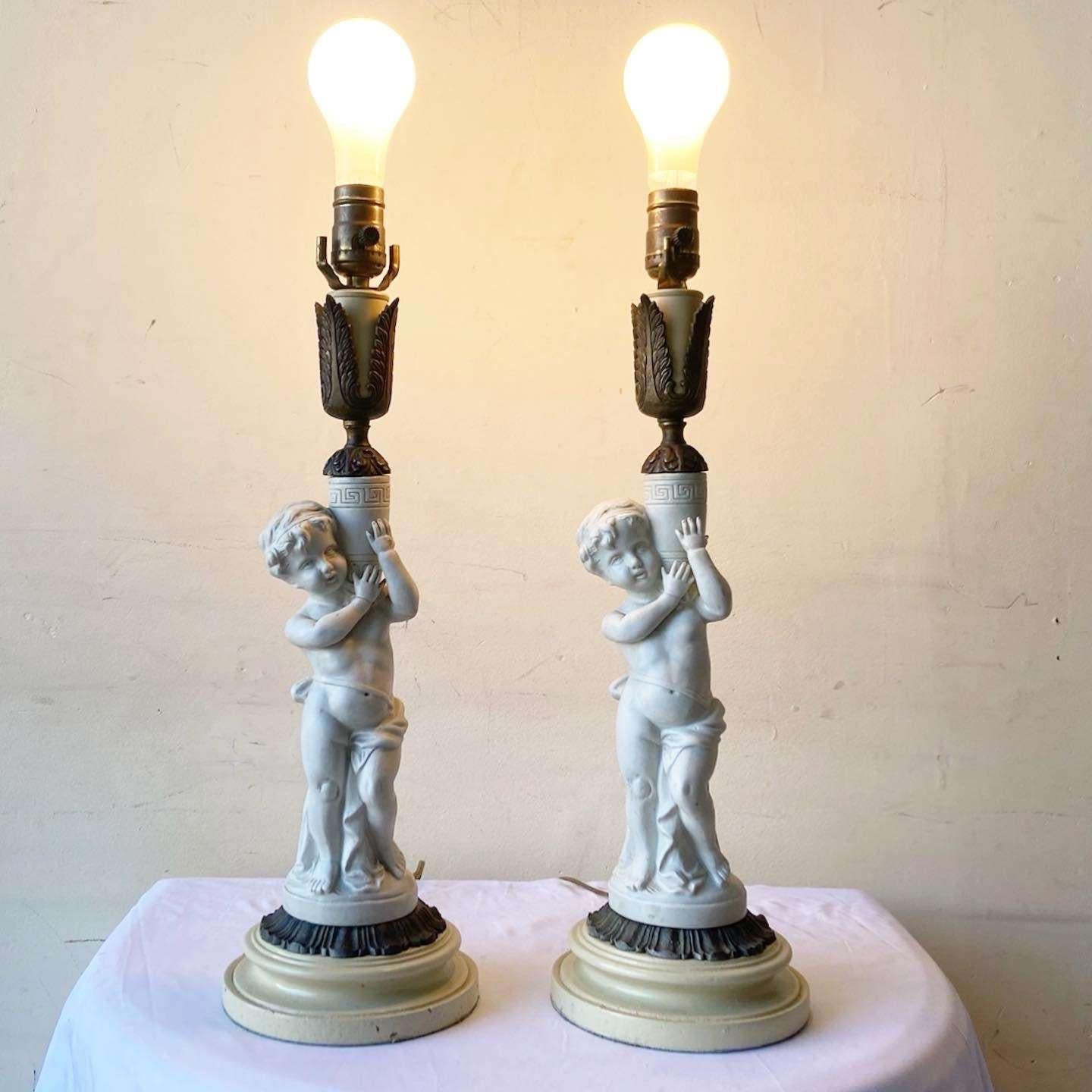 Exceptionnelle paire de lampes de table chérubin grec en céramique vintage. Un accent en laiton est placé sous le chérubin et au-dessus du vase qu'il tient.

Éclairage à 3 voies.
