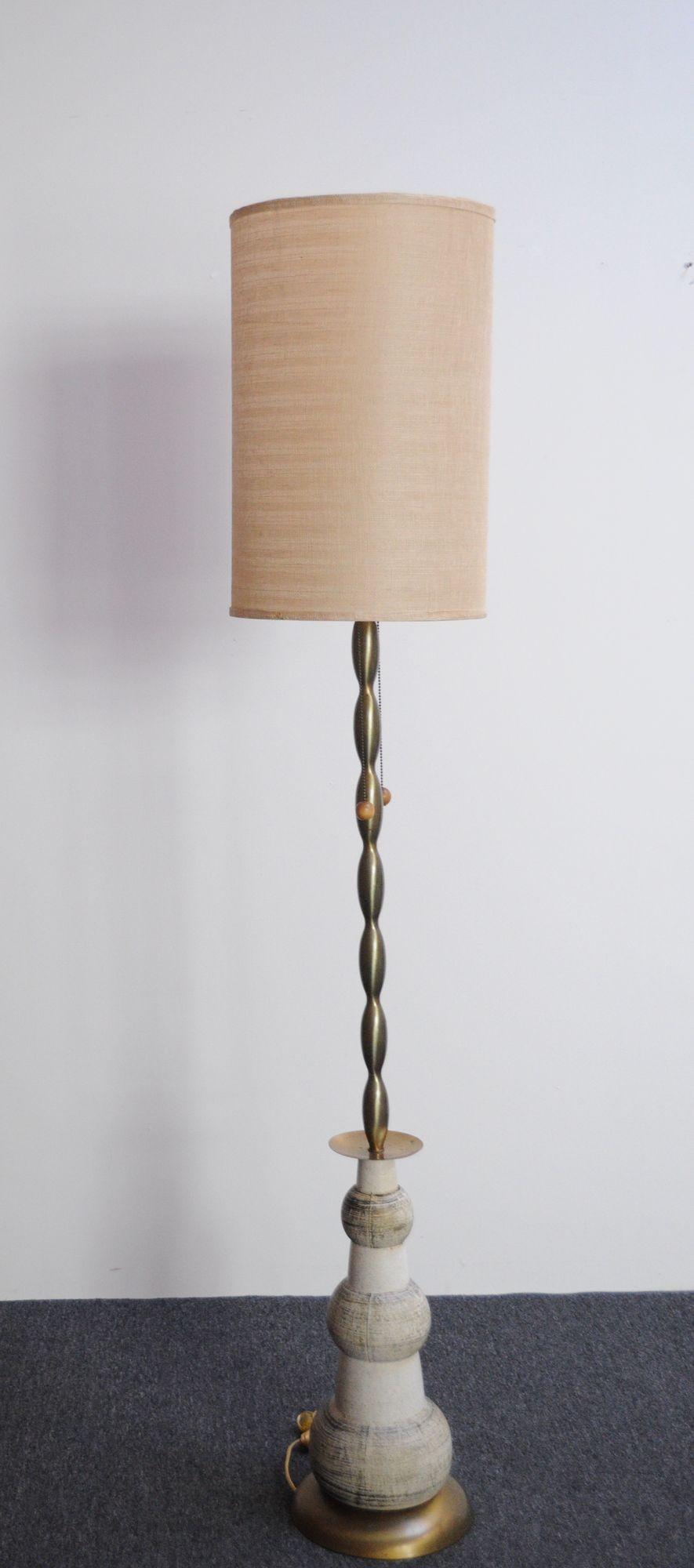 Glamorous and unique Hollywood Regency-Style floor lamp (ca. 1960s, USA).
Composed of a graduated ceramic orb base supporting a sculptural brass column stem with dual socket design, ring finial, and round pull string adornments.
Very good, vintage