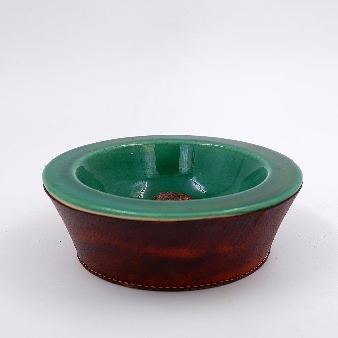Ceramic and leather in the Georges Jouve style
Materials: Ceramic (green) and leather (brown).
Condition: It has a small chip on the leather and a patina due to age.
Measures : Ø 17cm H:5,5cm