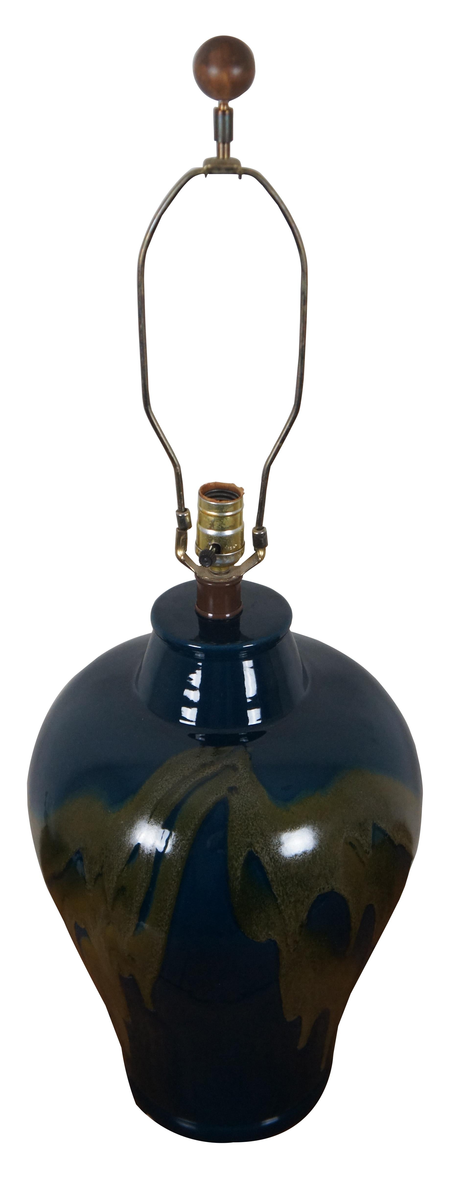 Vintage-Tischlampe in Form eines Ingwerglases mit olivgrüner Tropfglasur auf tiefem Blau.

Maße: 12
